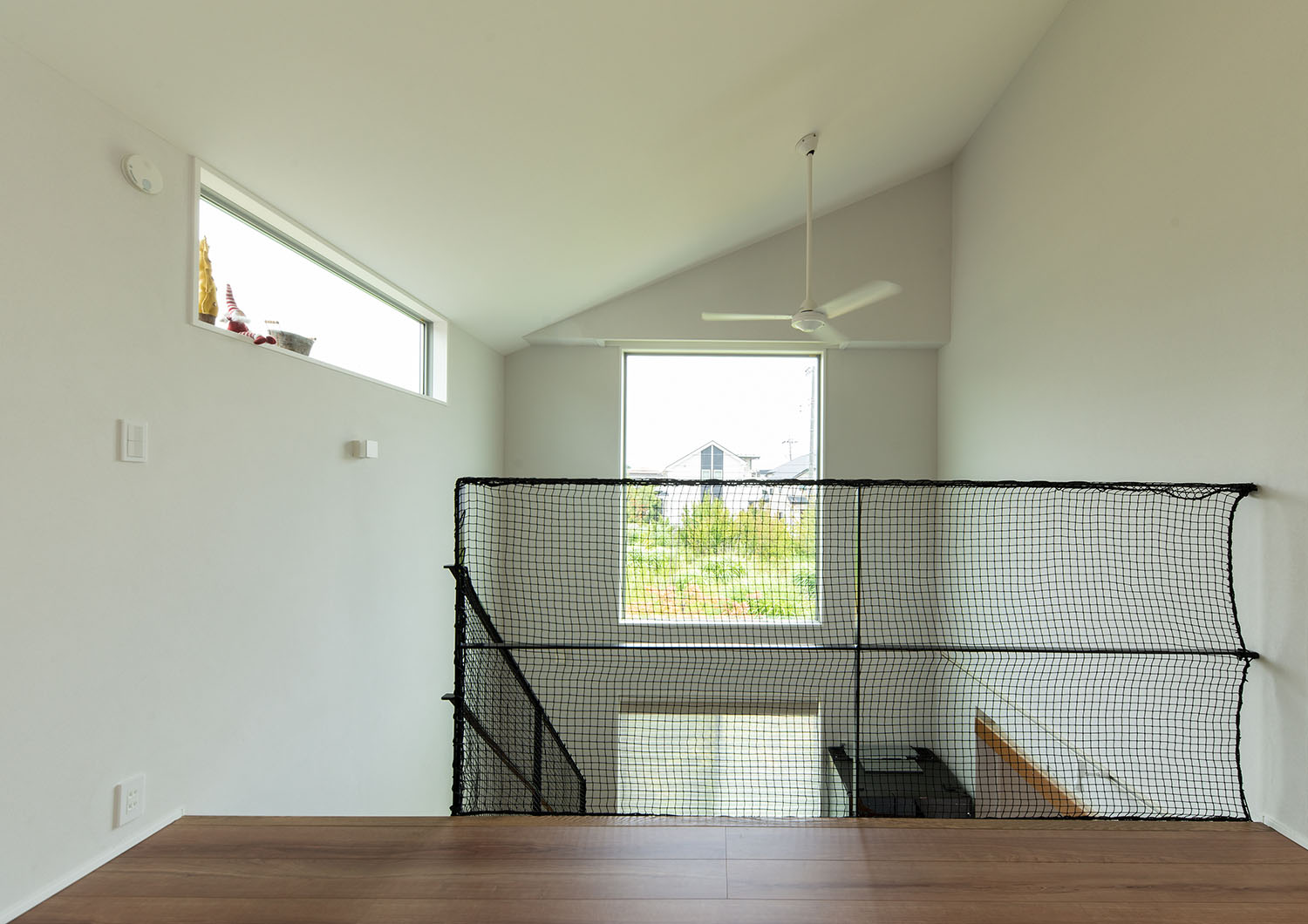 窓のある吹き抜けに面して手すりとネットが取り付けられている様子・デザイン住宅 注文住宅・デザイン住宅建築実例_『CASE663 シークエンス』_フリースペース