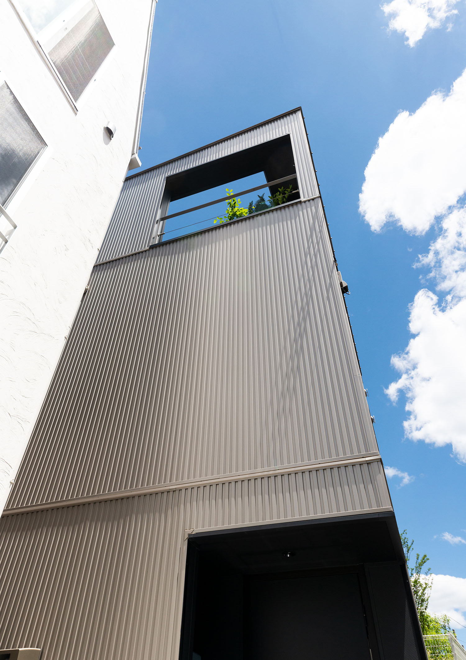 金属の外壁の三階建て住宅を見上げた様子・デザイン住宅 注文住宅・デザイン住宅建築実例_『CASE665 LUCE』_外観