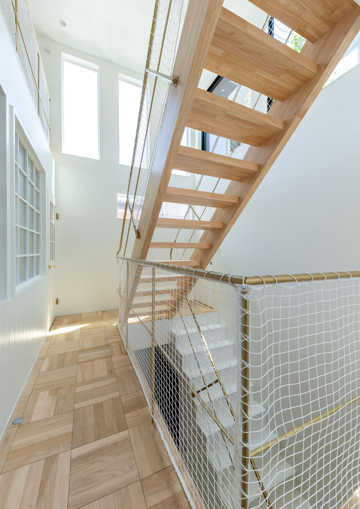 吹き抜けとなった木目の床から木のスケルトン階段が伸びている様子・デザイン住宅 注文住宅・デザイン住宅建築実例_『CASE665 LUCE』_階段