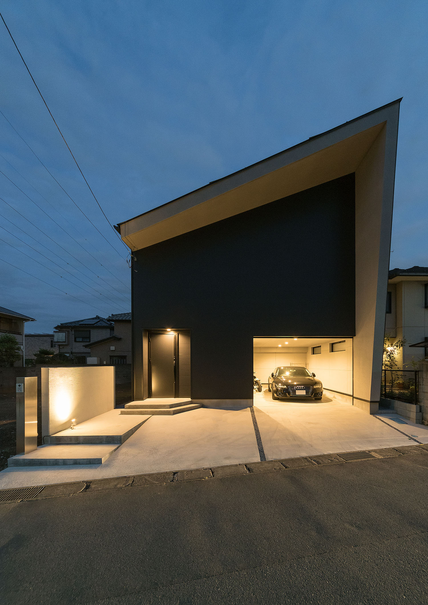 ガレージ内部と玄関が照らされる斜め屋根の住宅・デザイン住宅 注文住宅・デザイン住宅建築実例_『CASE667 コントラスト』_外観