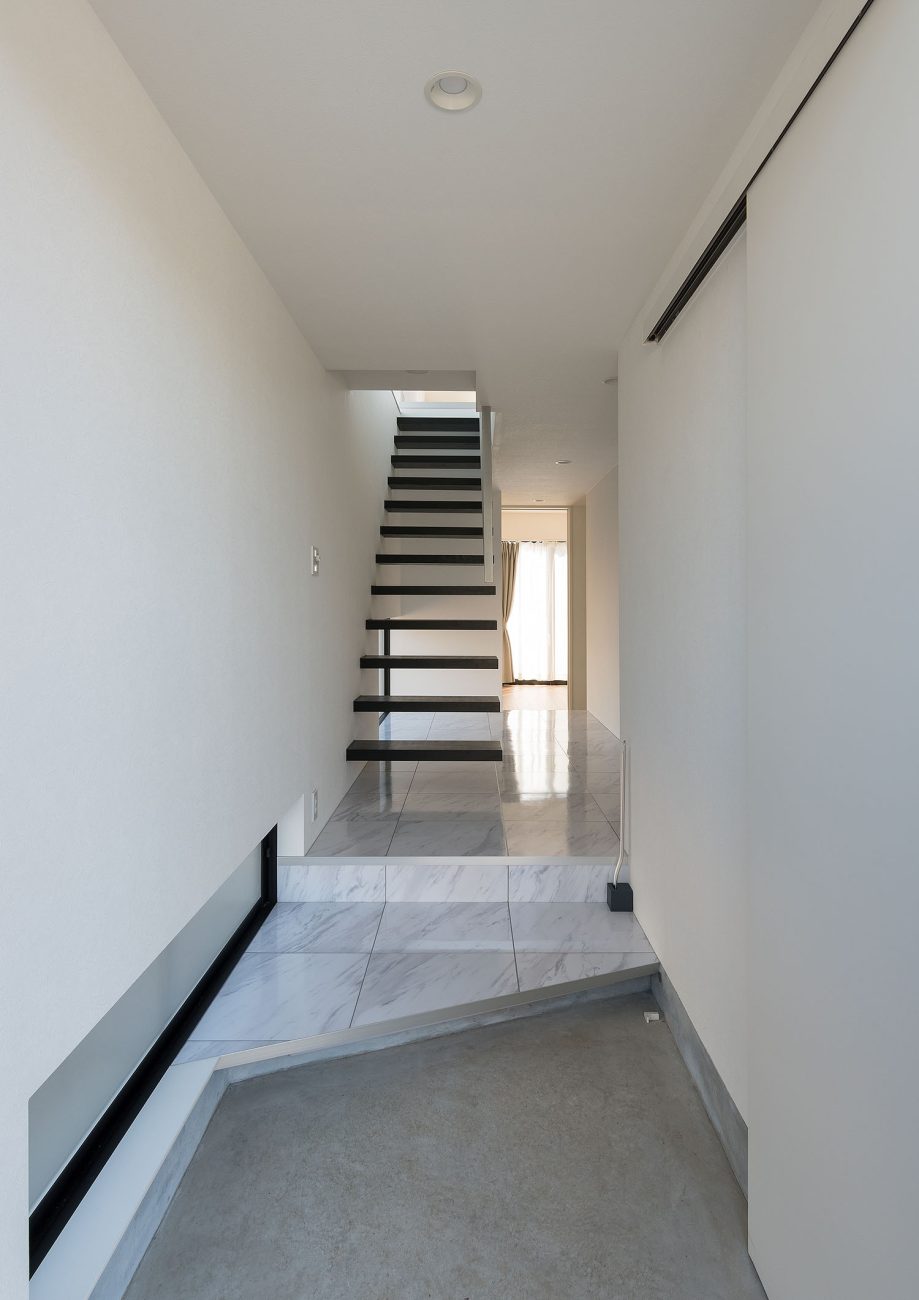 大理石風の玄関からスケルトン階段に繋がる様子・デザイン住宅 注文住宅・デザイン住宅建築実例_『CASE667 コントラスト』_玄関