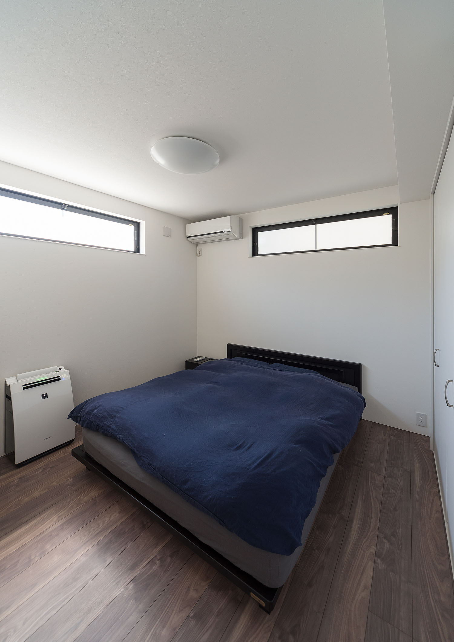 ネイビーのベッドが置かれたスリット窓のある寝室・デザイン住宅 注文住宅・デザイン住宅建築実例_『CASE667 コントラスト』_寝室