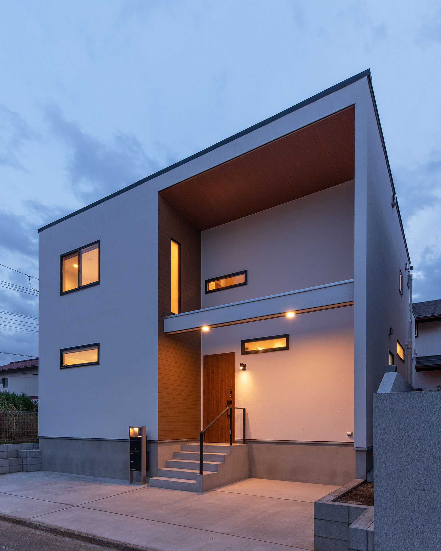 吹き抜けになった玄関ポーチの壁についたスリット窓から光が漏れる住宅・デザイン住宅 注文住宅・デザイン住宅建築実例_『CASE668 square up』_外観