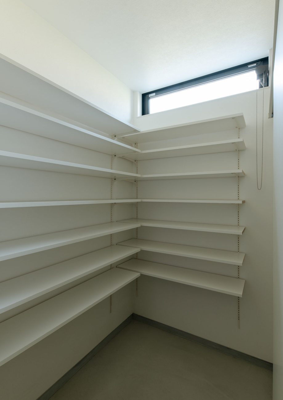 壁一面に白い可動棚を設けた、スリット窓のあるシューズインクローゼット・デザイン住宅 注文住宅・デザイン住宅建築実例_『CASE668 square up』_玄関