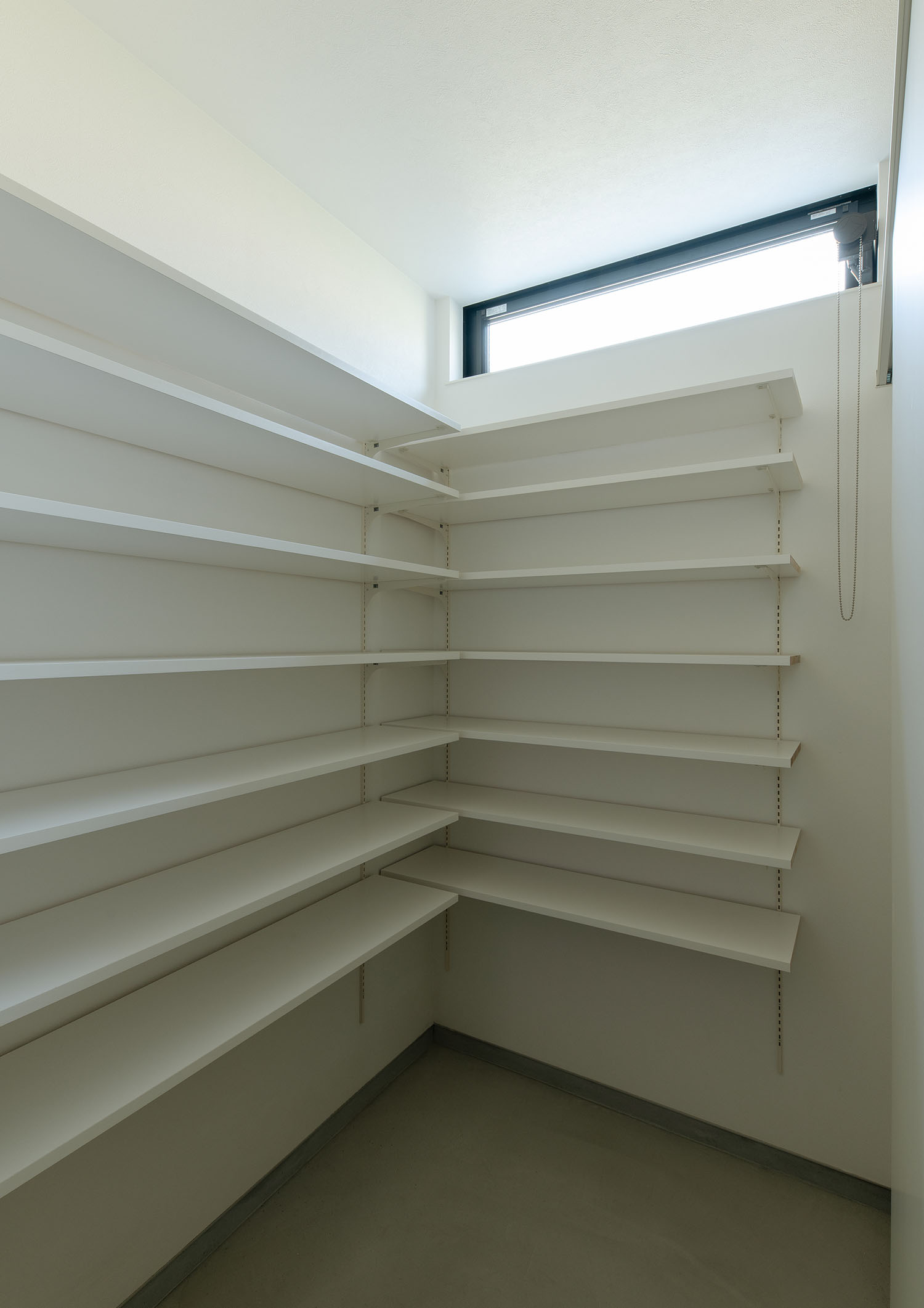 壁一面に白い可動棚を設けた、スリット窓のあるシューズインクローゼット・デザイン住宅 注文住宅・デザイン住宅建築実例_『CASE668 square up』_玄関