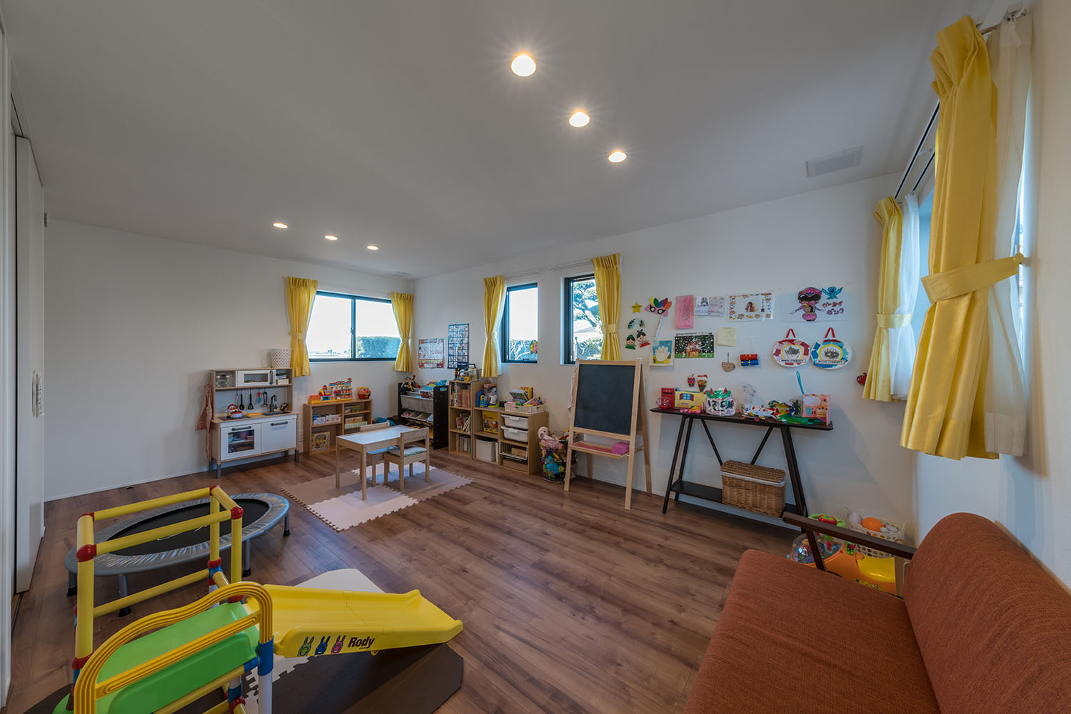 三方向にある窓に黄色のカーテンが付けられた、おもちゃや遊具のある部屋・デザイン住宅 注文住宅・デザイン住宅建築実例_『CASE671 実りの平屋』_子供部屋