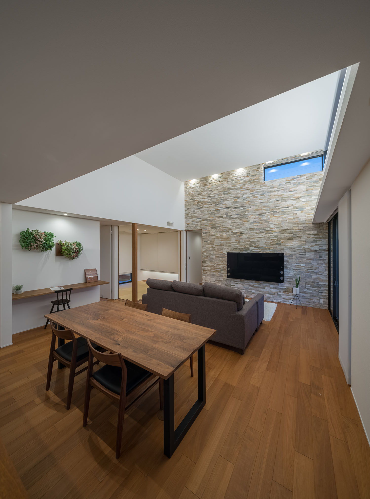 壁付けデスクのワークスペースがダウンライトで照らされるLDK・デザイン住宅 注文住宅・デザイン住宅建築実例_『CASE671 実りの平屋』_LDK