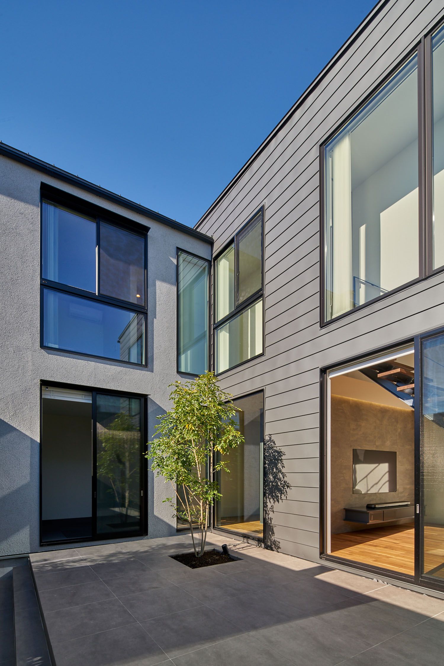 シンボルツリーがある黒いタイルの中庭・デザイン住宅 注文住宅・デザイン住宅建築実例_『CASE670 静かな形の家』_中庭