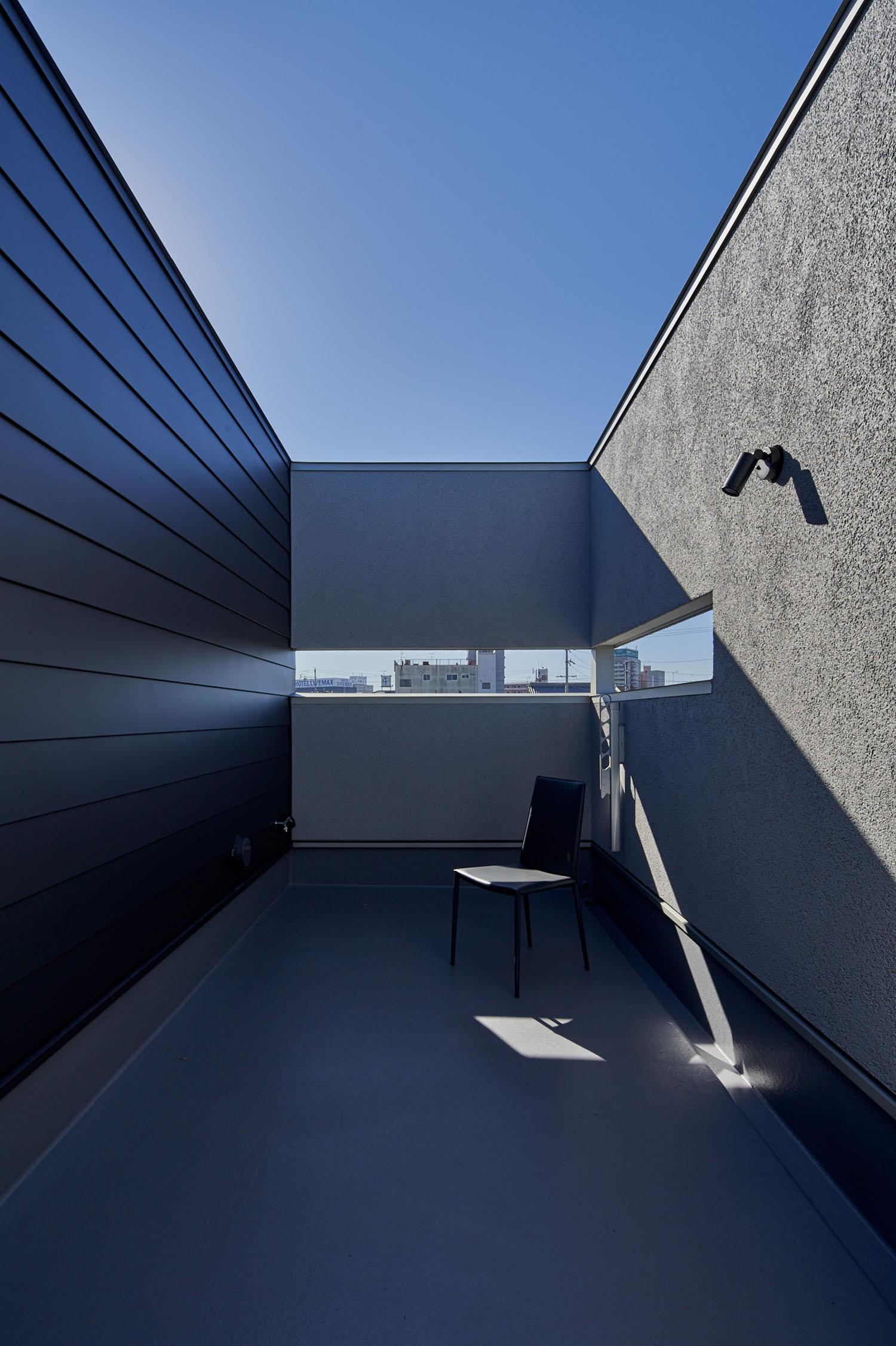 スリットがあり、壁にスポットライトが付けられたルーフバルコニー・デザイン住宅 注文住宅・デザイン住宅建築実例_『CASE670 静かな形の家』_テラス・バルコニー