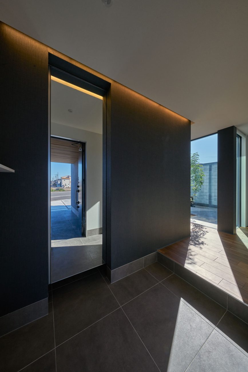 正面に鏡があるタイルの玄関・デザイン住宅 注文住宅・デザイン住宅建築実例_『CASE670 静かな形の家』_玄関