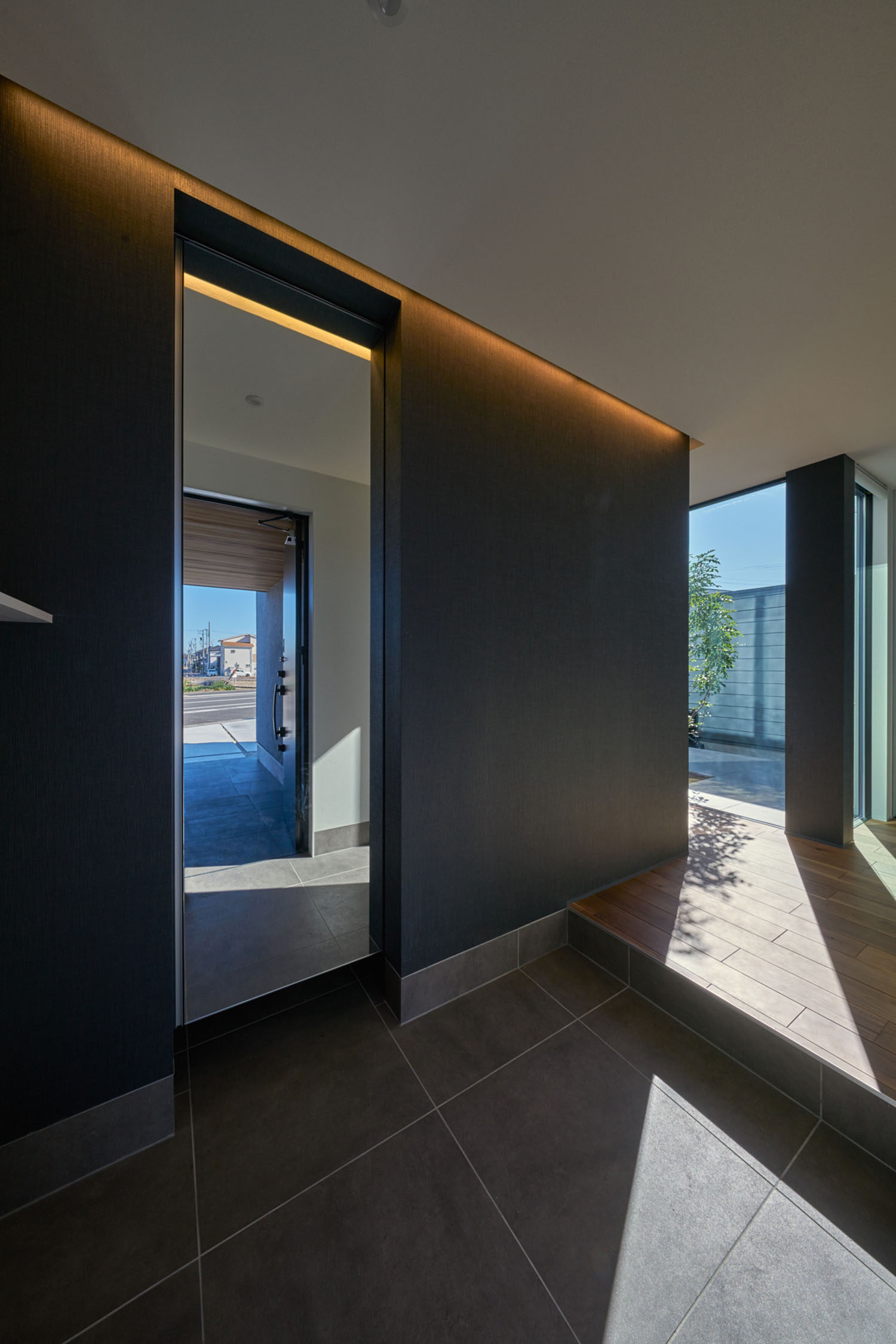 正面に鏡があるタイルの玄関・デザイン住宅 注文住宅・デザイン住宅建築実例_『CASE670 静かな形の家』_玄関