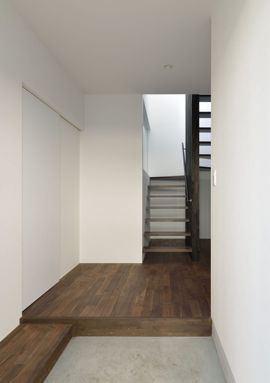 モルタルの玄関の先にフローリングとスケルトン階段が見える様子・デザイン住宅 注文住宅・デザイン住宅建築実例_『CASE672 Trick Art』_玄関