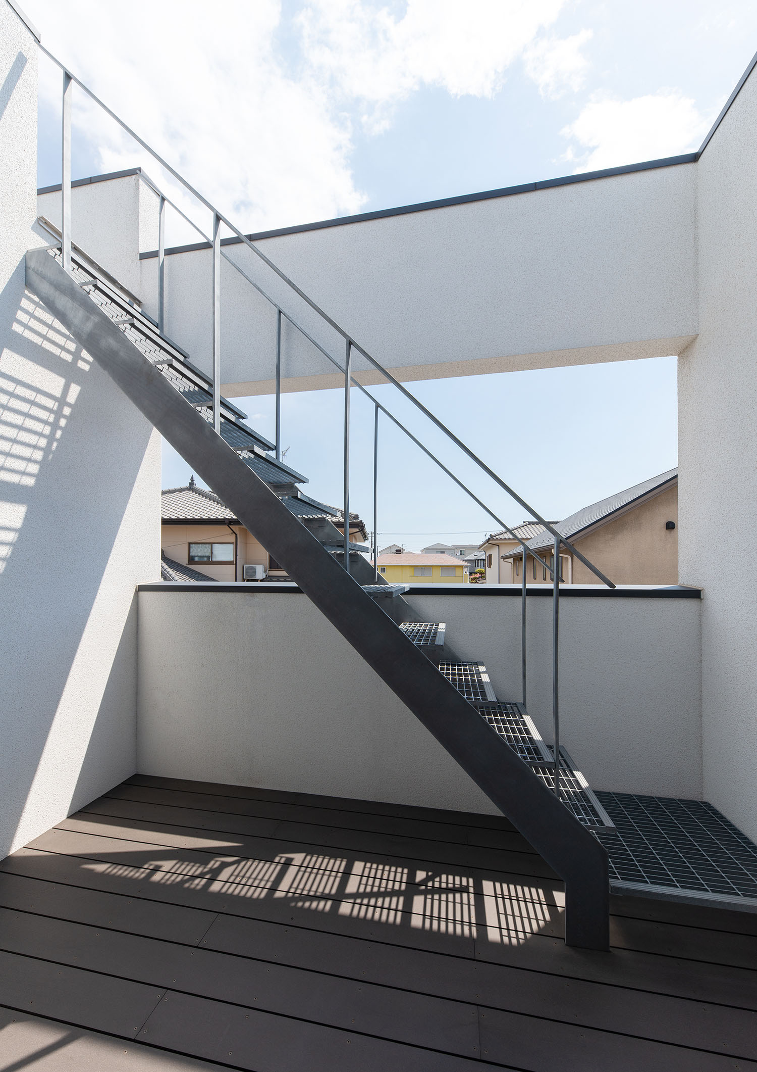 ウッドデッキのバルコニーに、屋上へと繋がる階段がある様子・ラグジュアリーな住宅 注文住宅・デザイン住宅建築実例_『CASE673 Ganache』_テラス・バルコニー