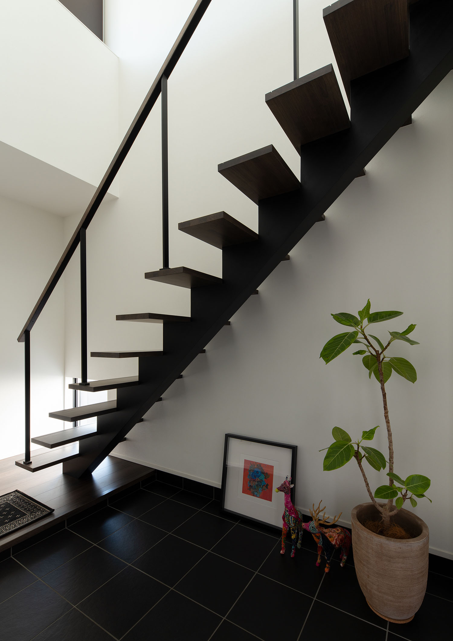 タイルの玄関の上を横切るように設けられたスケルトン階段・ラグジュアリーな住宅 注文住宅・デザイン住宅建築実例_『CASE673 Ganache』_階段