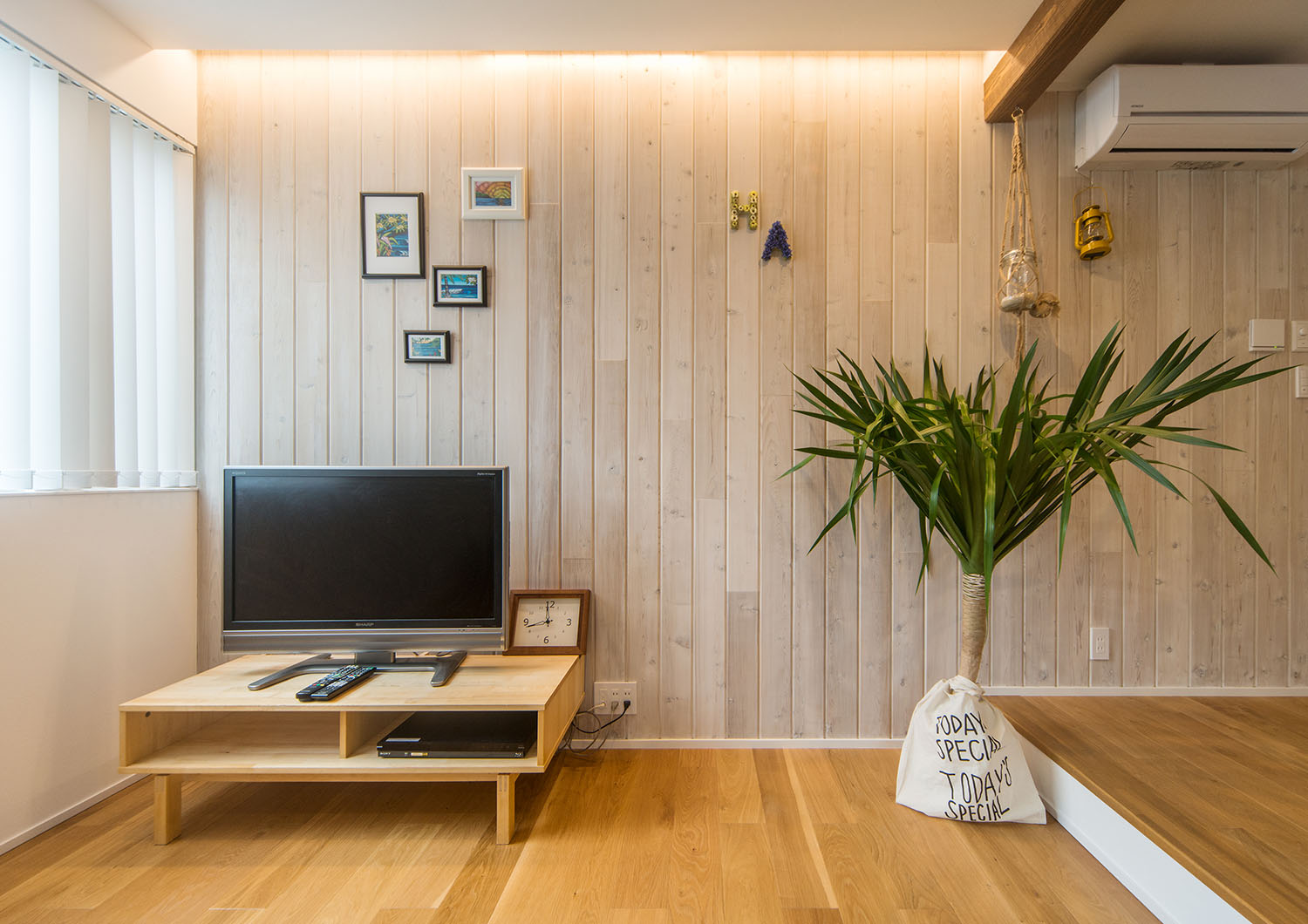 木のアクセントウォールにアートが飾られているLDK・Gardenのある家 注文住宅・デザイン住宅建築実例_『CASE674 Gardenのある家』_LDK