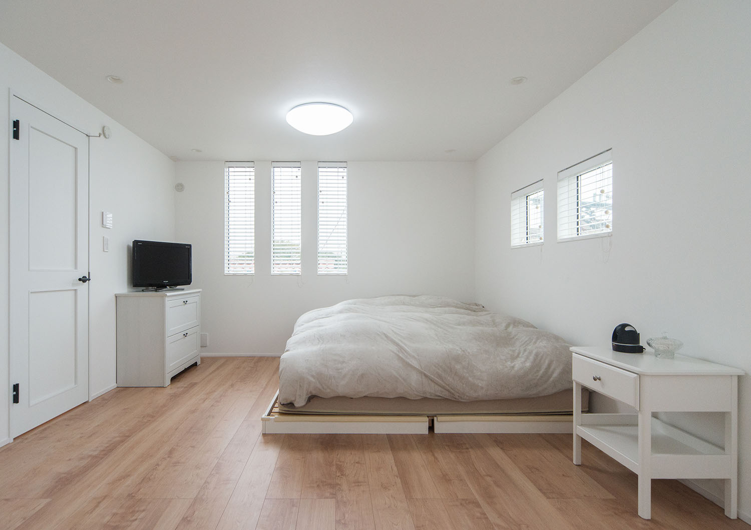 白いベッドや、テレビのある白い壁の寝室・デザイン住宅 注文住宅・デザイン住宅建築実例_『CASE674 Gardenのある家』_寝室