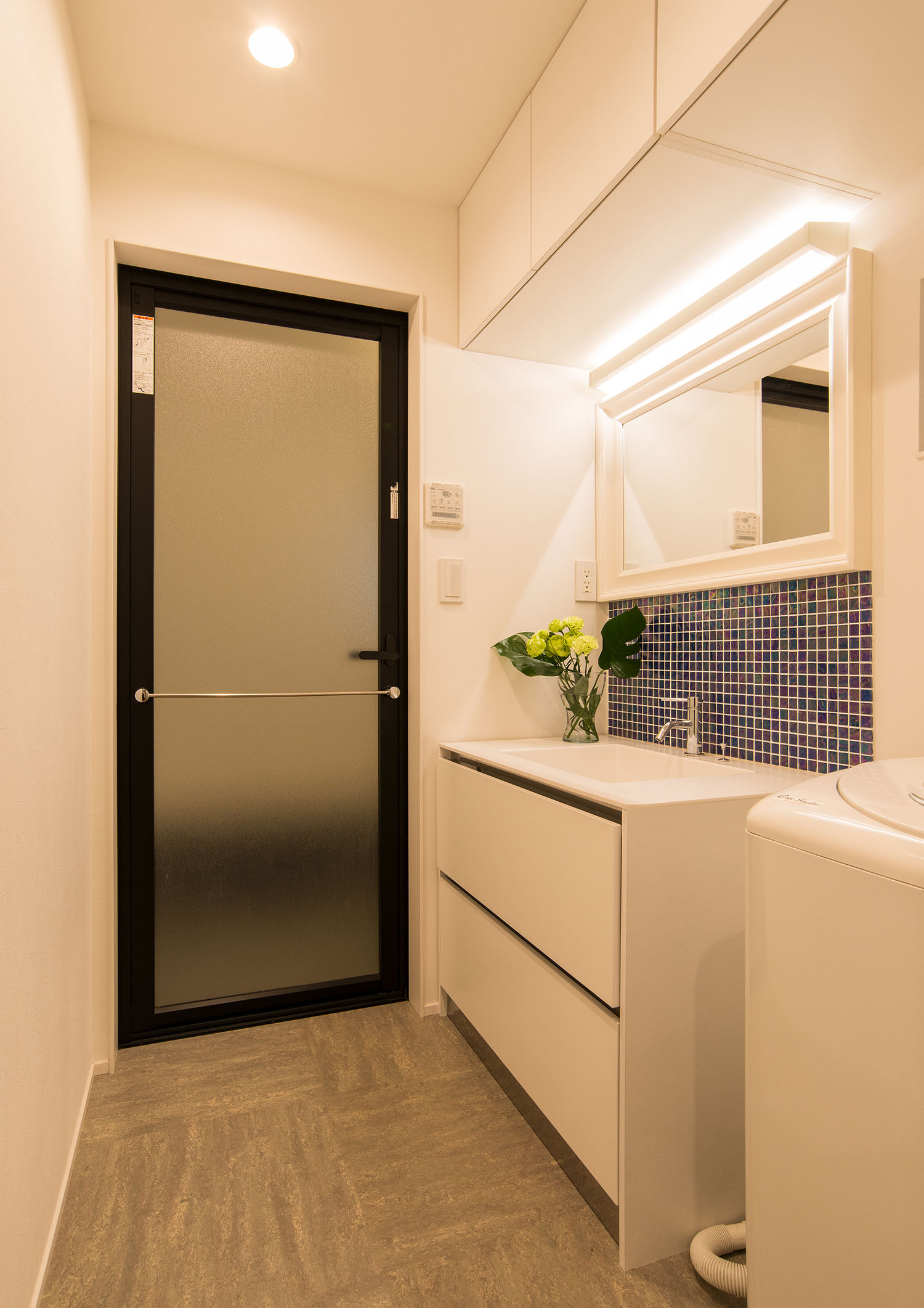 タイルがアクセントとなった洗面台の奥に、曇りガラスの扉が付けられている様子・デザイン住宅 注文住宅・デザイン住宅建築実例_『CASE674 Gardenのある家』_浴室・洗面所