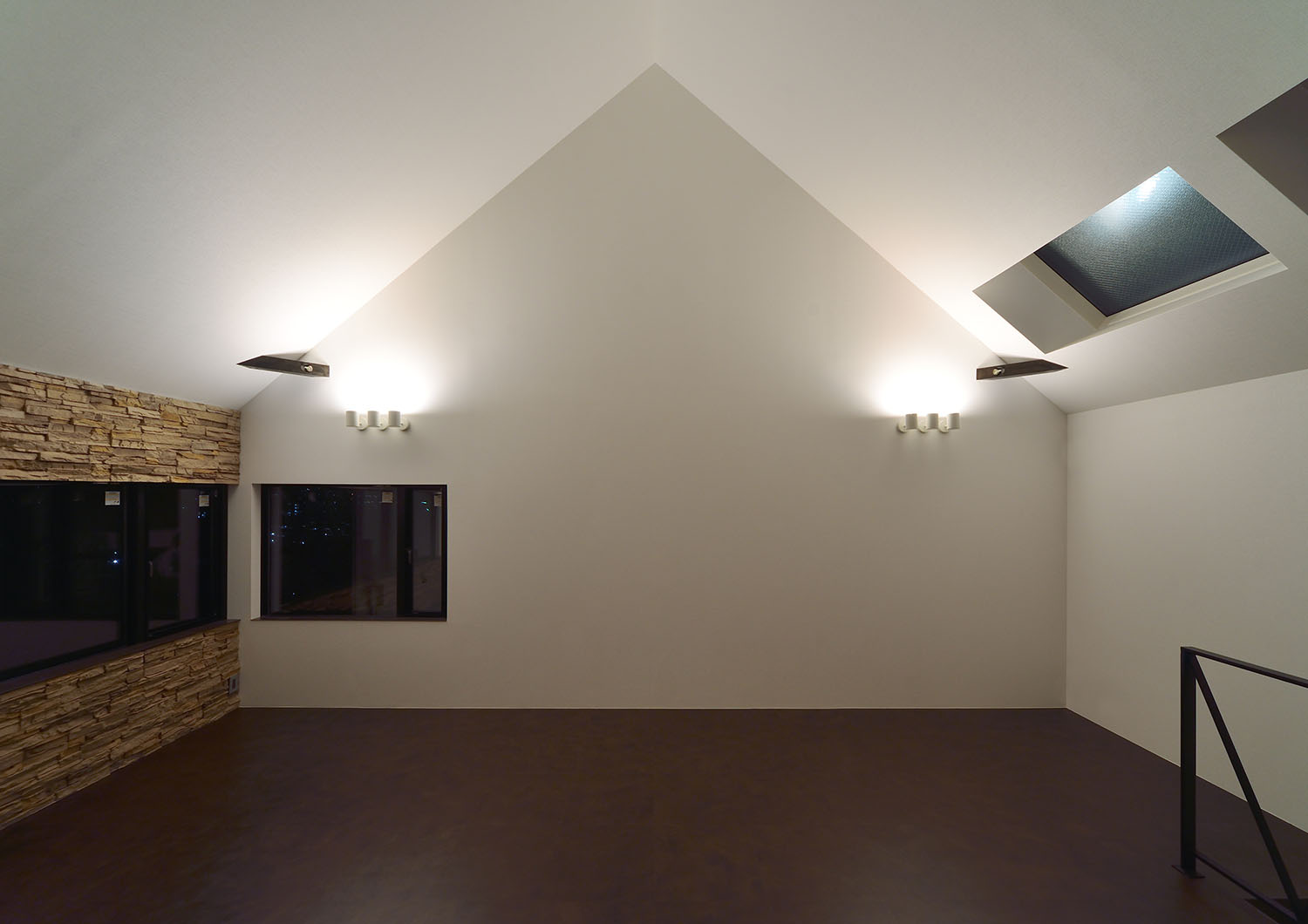 白い壁に取り付けられた照明に照らされる三角屋根のLDK・デザイン住宅 注文住宅・デザイン住宅建築実例_『CASE676 箱を包む小屋裏』_LDK