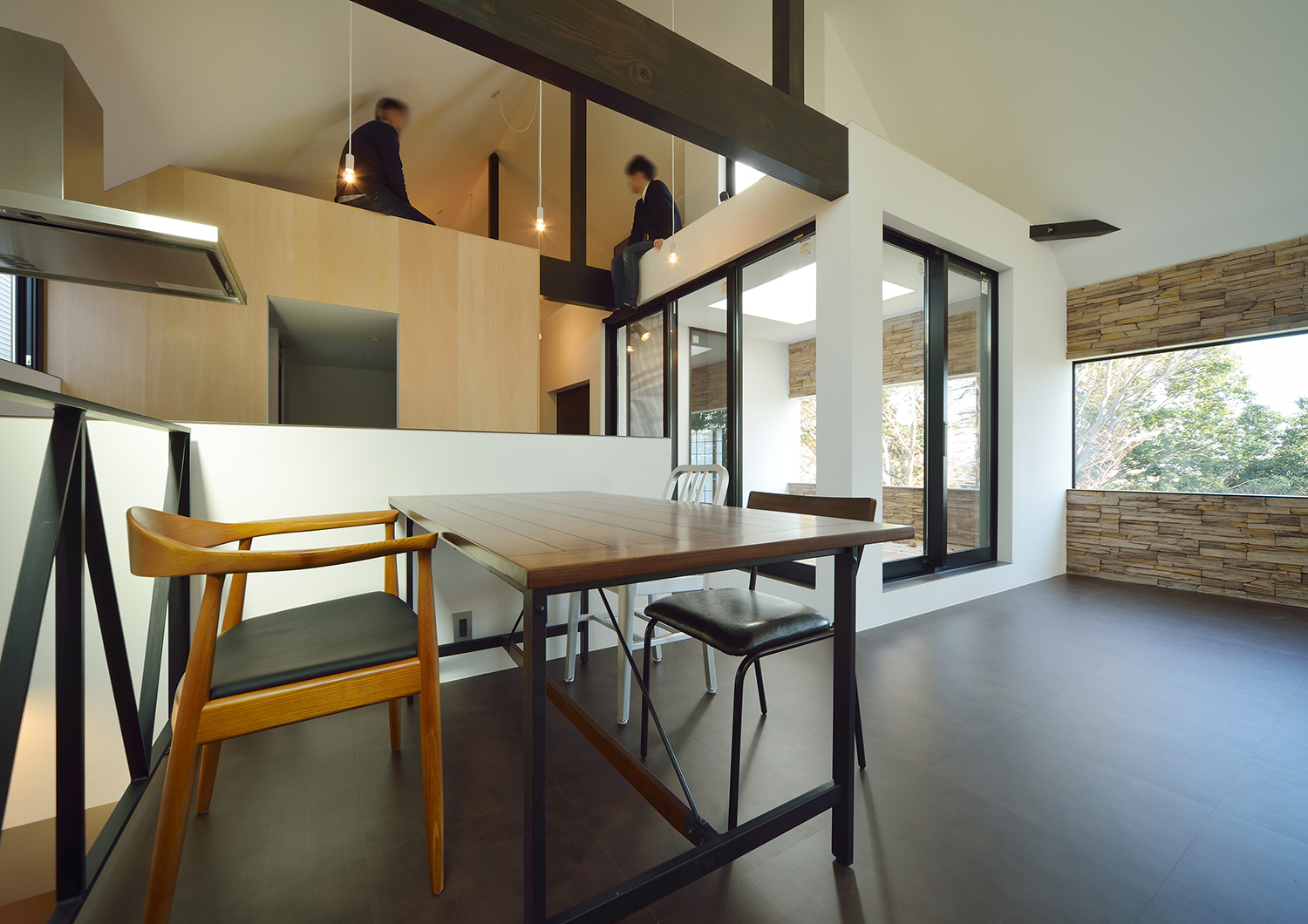 高天井の部分に人が腰かけているLDK・デザイン住宅 注文住宅・デザイン住宅建築実例_『CASE676 箱を包む小屋裏』_LDK