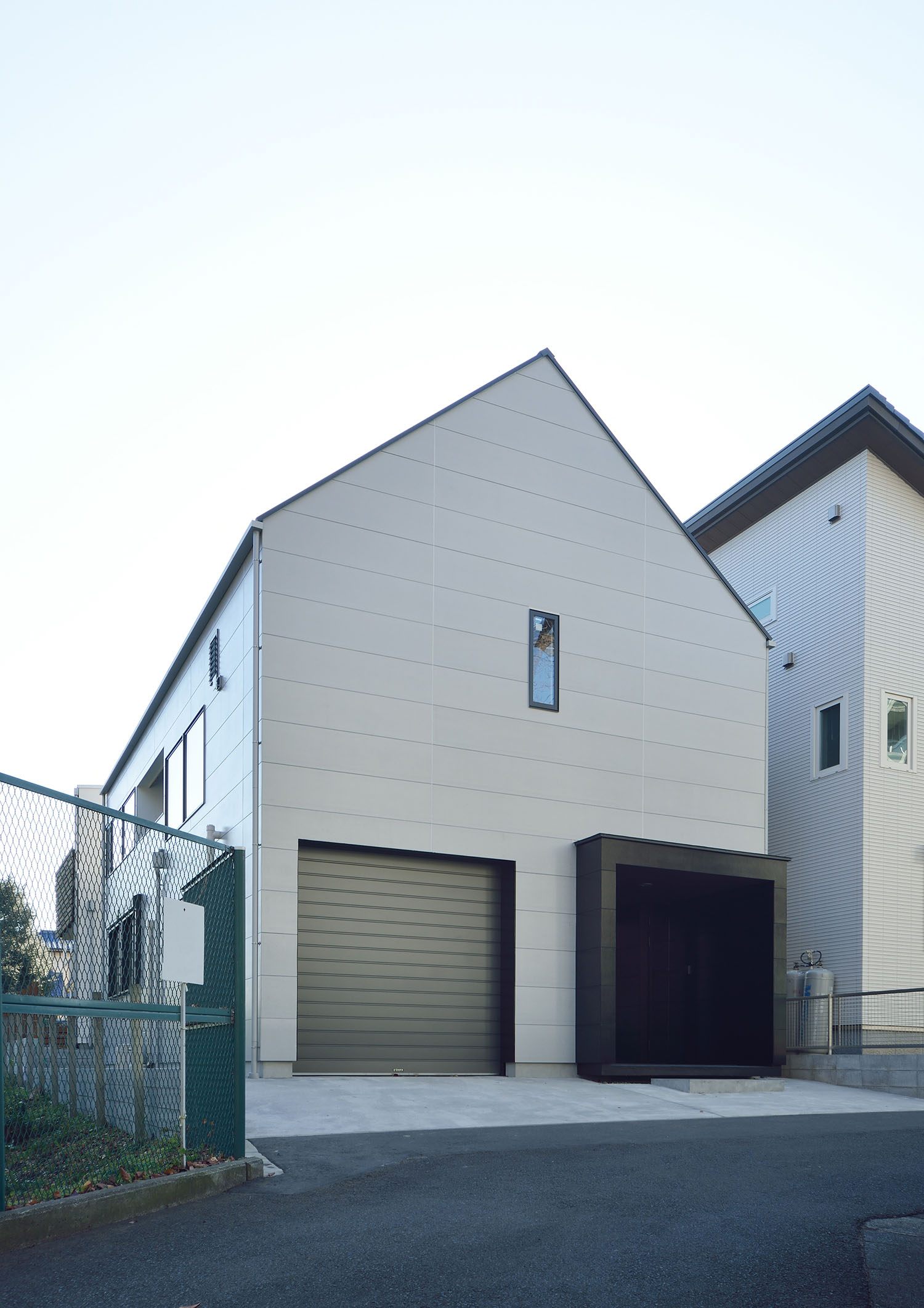 ガレージや小さなスリット窓がある三角屋根の住宅の外観・デザイン住宅 注文住宅・デザイン住宅建築実例_『CASE676 箱を包む小屋裏』_外観