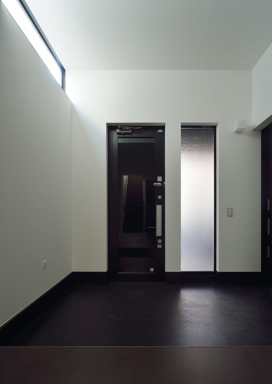 黒い玄関扉の隣にスリット窓がある様子・デザイン住宅 注文住宅・デザイン住宅建築実例_『CASE676 箱を包む小屋裏』_玄関