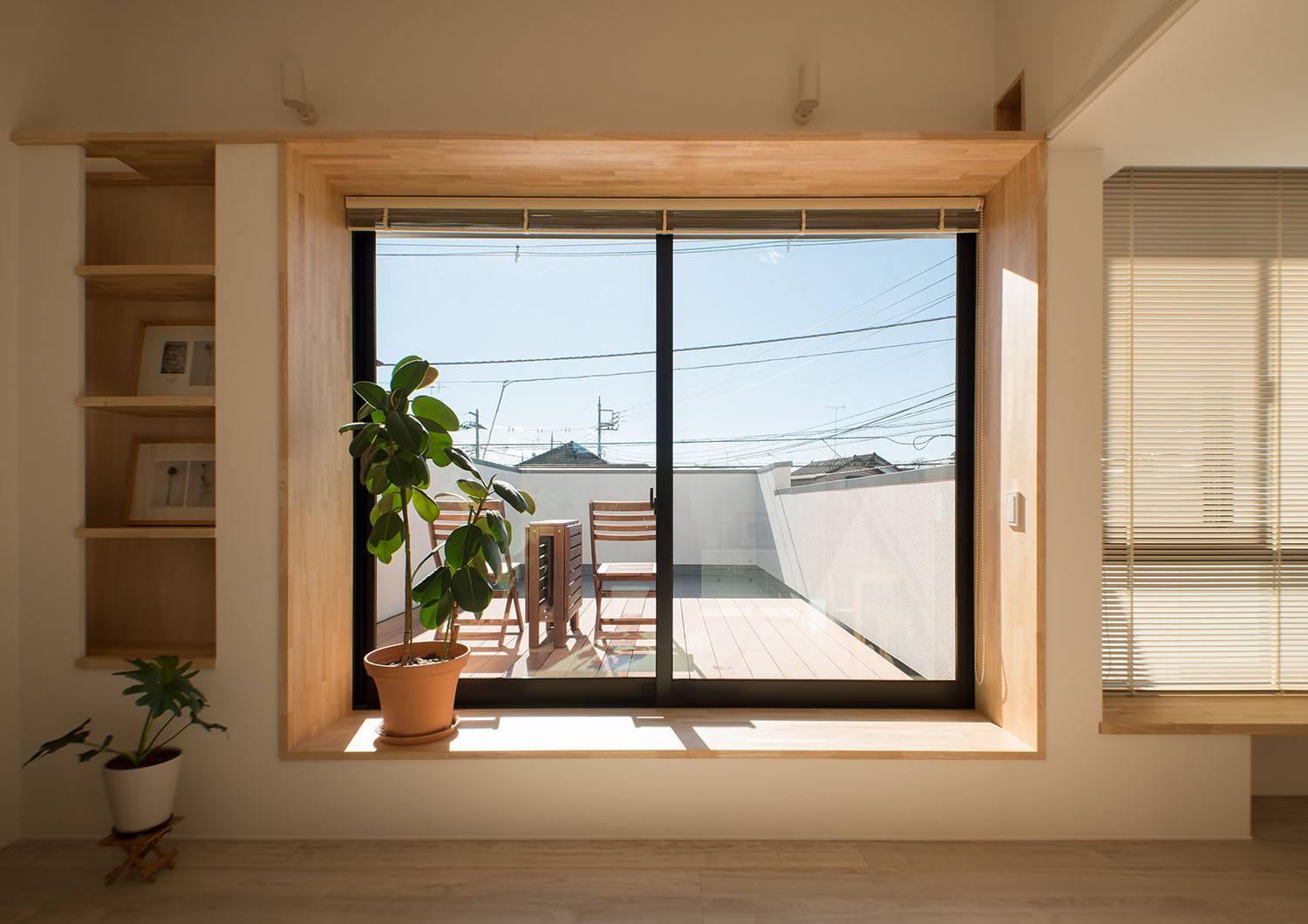 ウッドデッキのバルコニーへと繋がる大きな窓があるLDK・デザイン住宅 注文住宅・デザイン住宅建築実例_『CASE677 中庭が繋ぐ家族の気配』_LDK