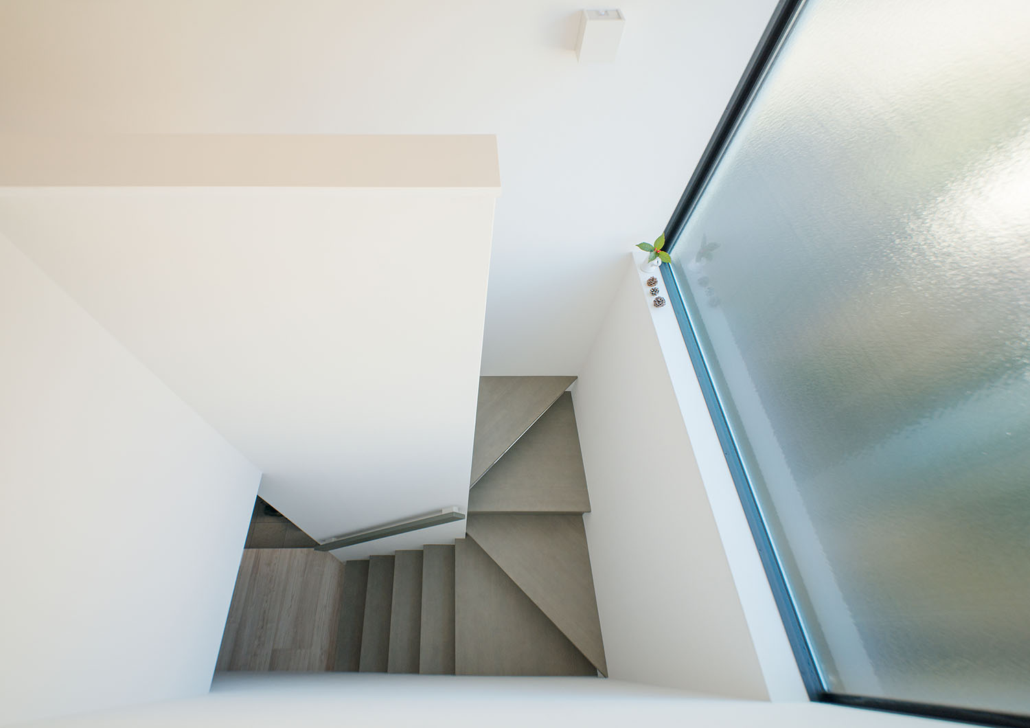 曇りガラスの窓が設けられたグレーの回り階段・デザイン住宅 注文住宅・デザイン住宅建築実例_『CASE677 中庭が繋ぐ家族の気配』_階段