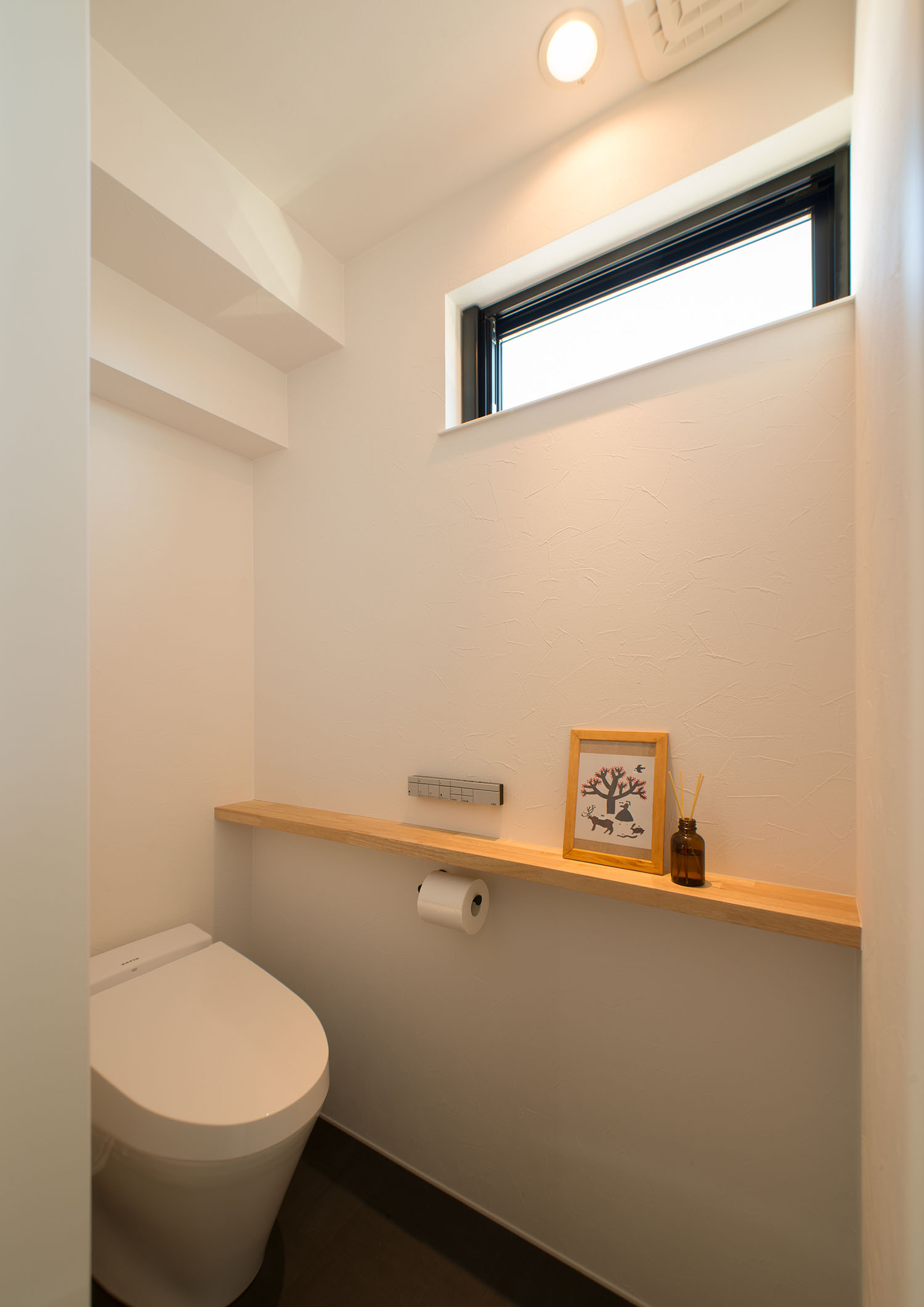 スリット窓や、インテリアを飾ることが出来る棚を設けたトイレ・デザイン住宅 注文住宅・デザイン住宅建築実例_『CASE677 中庭が繋ぐ家族の気配』_トイレ