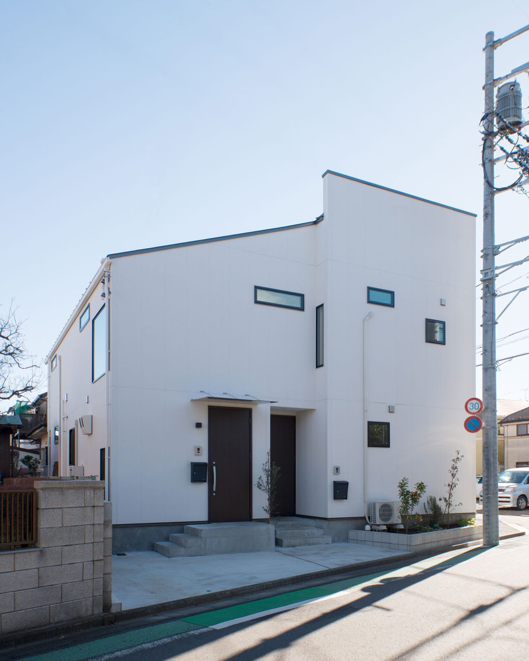 白い外壁に小さな窓やスリット窓が設けられた住宅の外観・デザイン住宅 注文住宅・デザイン住宅建築実例_『CASE677 中庭が繋ぐ家族の気配』_外観