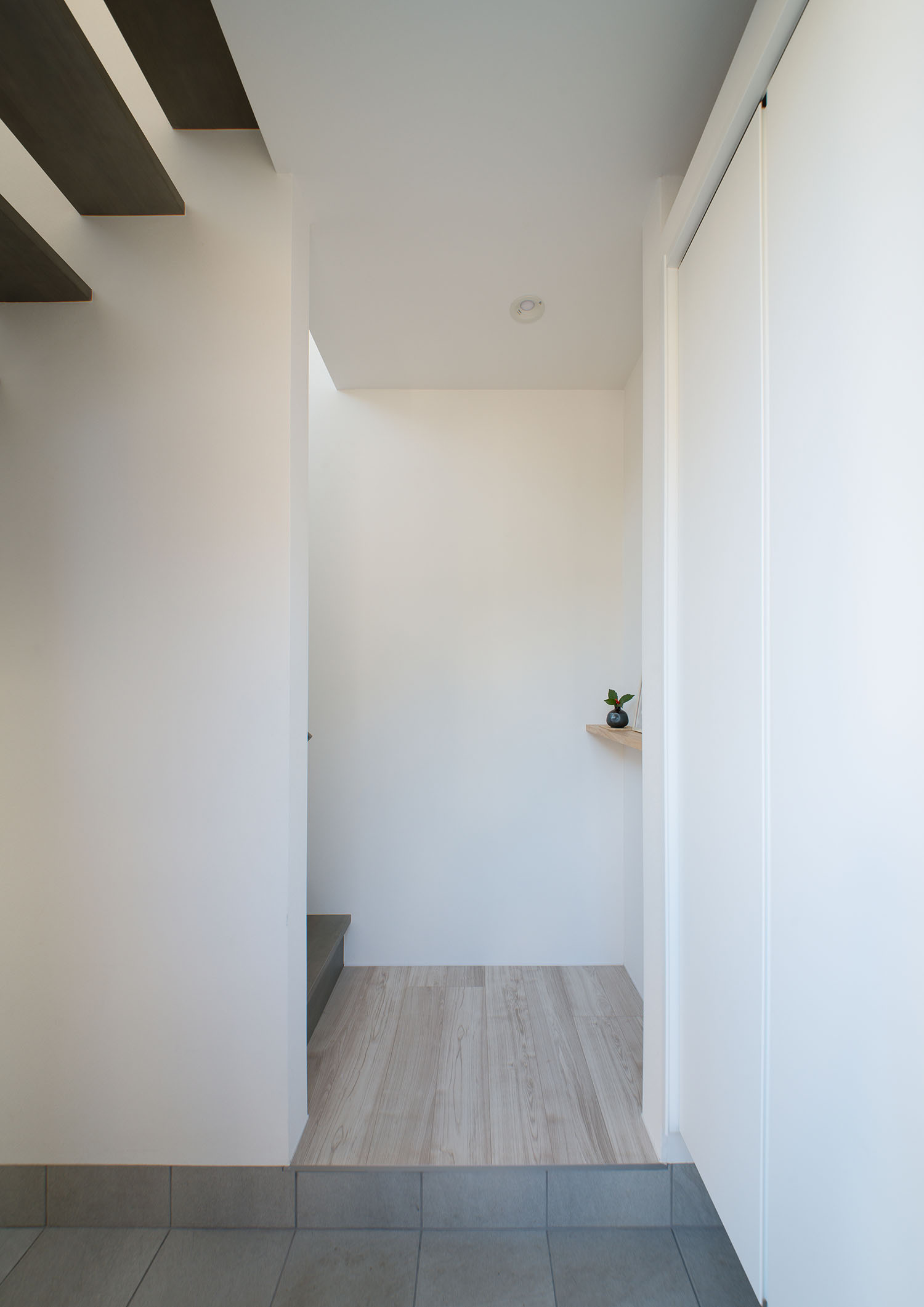 タイルの玄関を入るとすぐ階段へと繋がる様子・デザイン住宅 注文住宅・デザイン住宅建築実例_『CASE677 中庭が繋ぐ家族の気配』_玄関