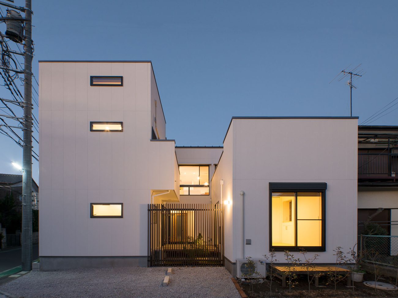 スリット窓やテラスに面する窓から光が漏れる白い外壁の住宅・デザイン住宅 注文住宅・デザイン住宅建築実例_『CASE677 中庭が繋ぐ家族の気配』_外観