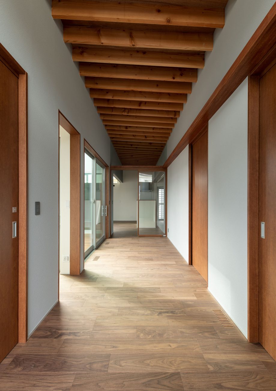 部屋の扉が木で統一された、梁見せ天井の廊下・デザイン住宅 注文住宅・デザイン住宅建築実例_『CASE680  寛か(くつろか)な平屋』_玄関