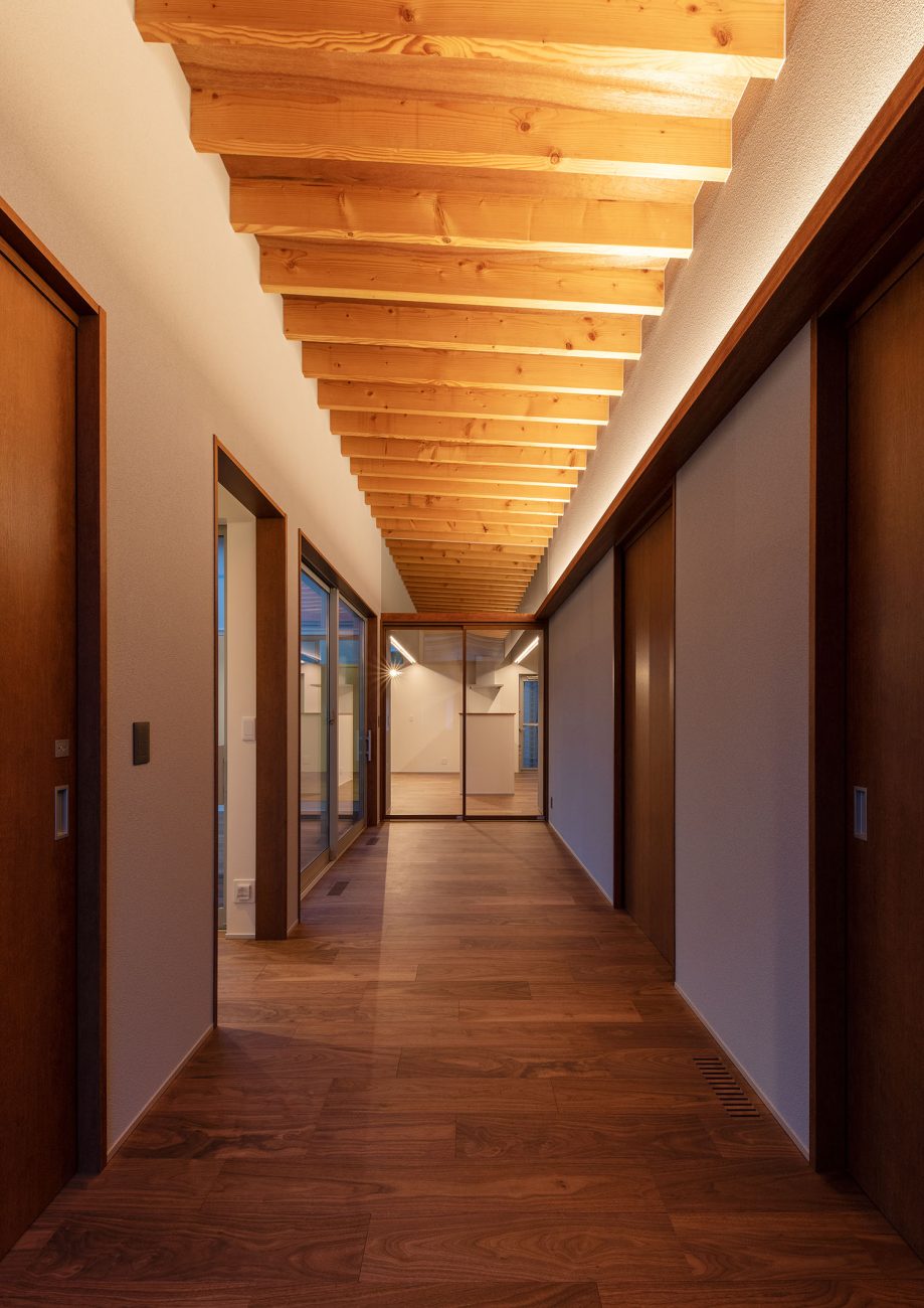 梁見せ天井に間接照明が取り付けられた廊下・デザイン住宅 注文住宅・デザイン住宅建築実例_『CASE680  寛か(くつろか)な平屋』_玄関