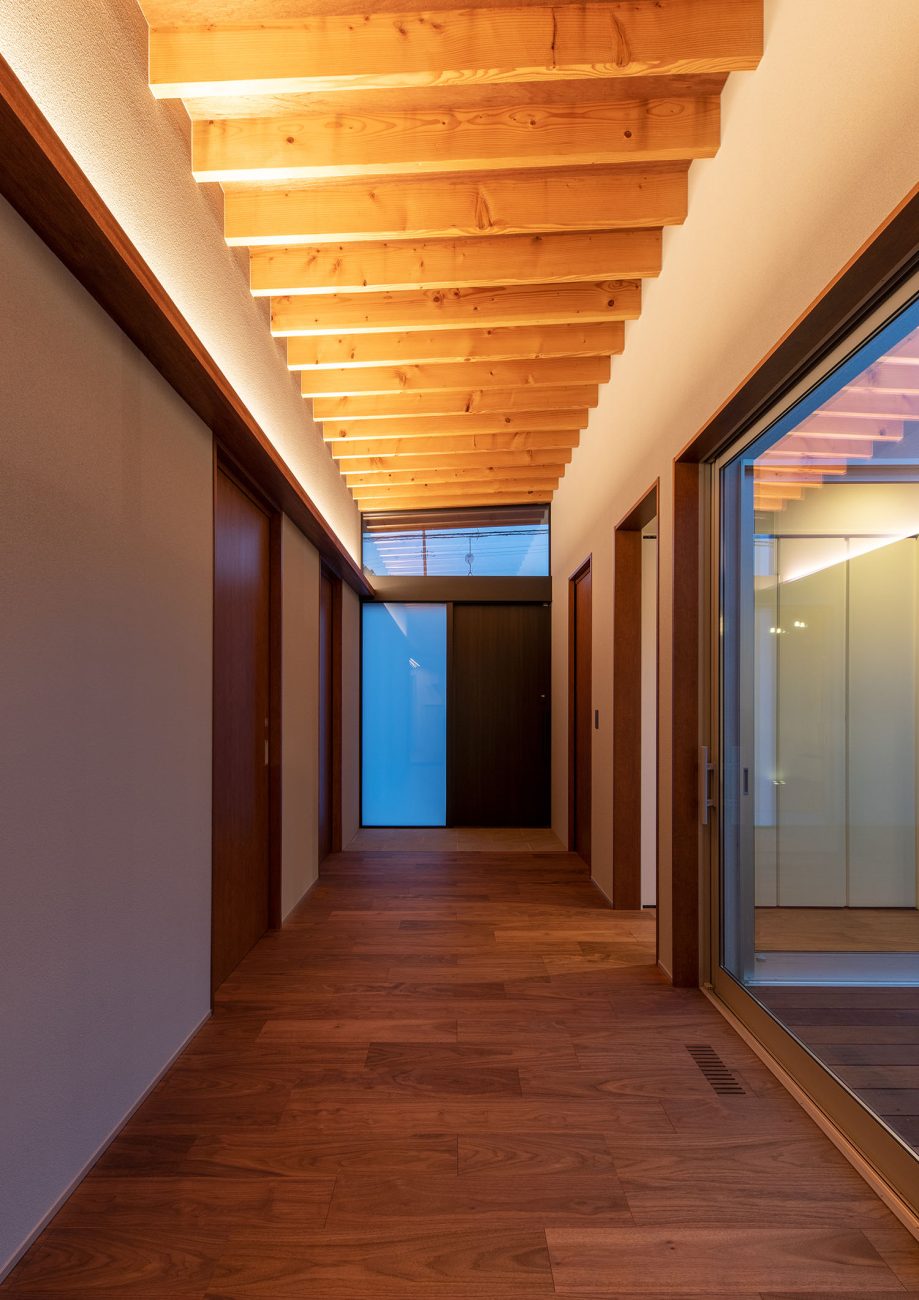 間接照明によって梁見せ天井が照らされる廊下・デザイン住宅 注文住宅・デザイン住宅建築実例_『CASE680  寛か(くつろか)な平屋』_玄関