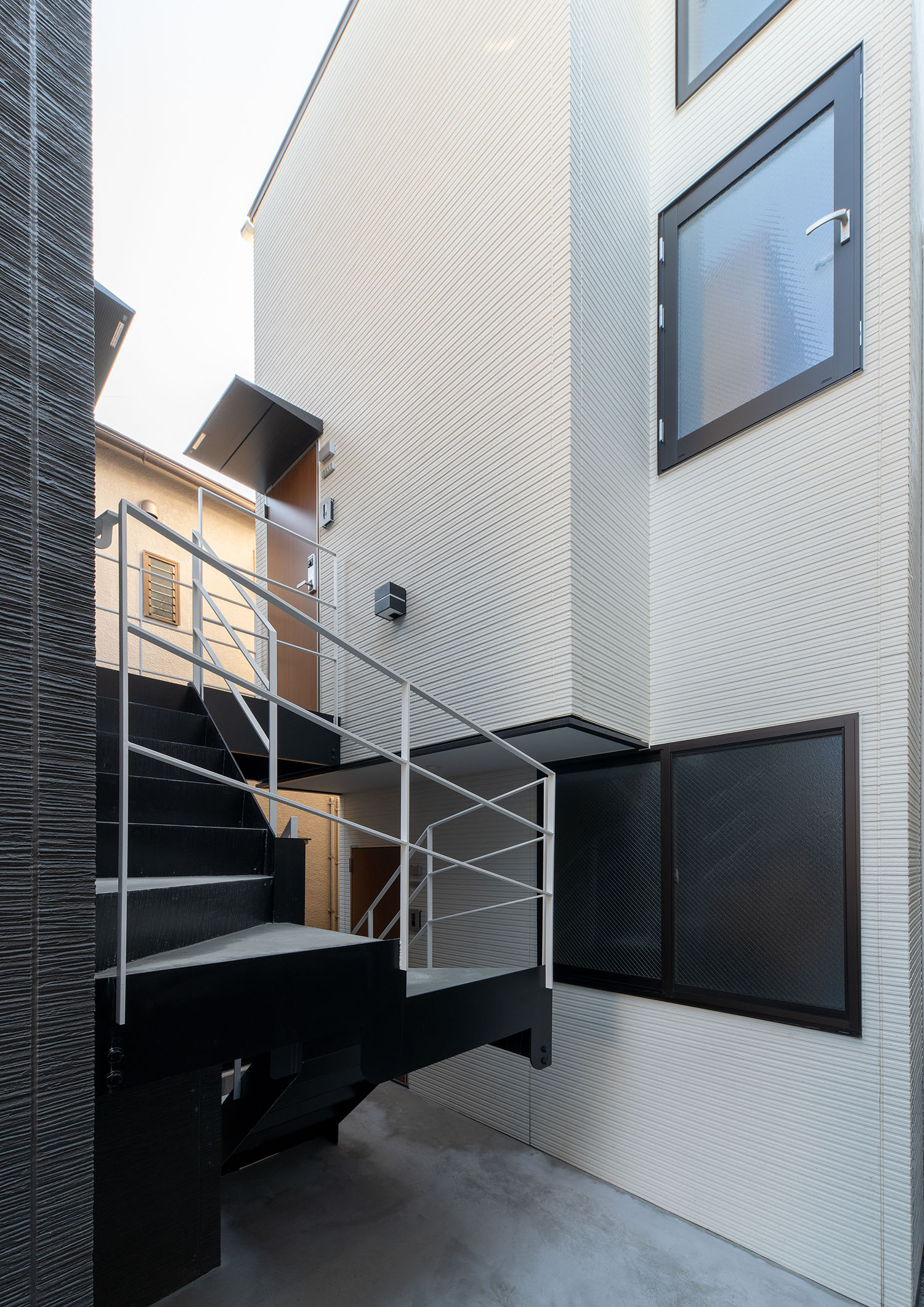 螺旋の外階段がある、白い外壁の建物・賃貸併用住宅 注文住宅・デザイン住宅建築実例_『CASE681  penche'　「パンシェ」の家』_外観