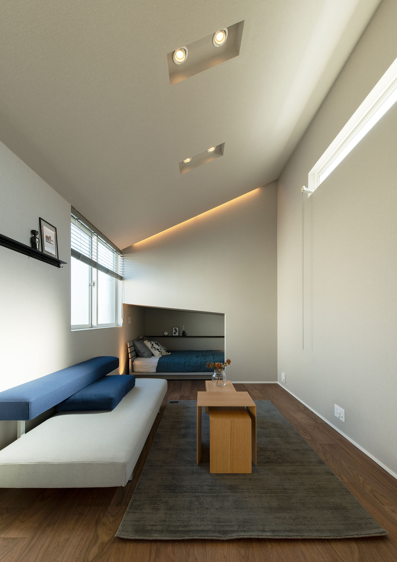 屋根が斜めになっており、壁を切り取るような形でベッドが置かれている部屋・賃貸併用住宅 注文住宅・デザイン住宅建築実例_『CASE681  penche'　「パンシェ」の家』_LDK