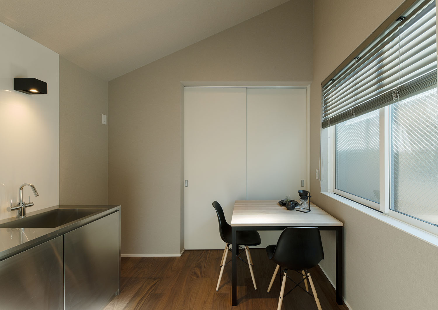 屋根が斜めになっている、レンジフードやインテリアが黒で統一されたダイニングキッチン・賃貸併用住宅 注文住宅・デザイン住宅建築実例_『CASE681  penche'　「パンシェ」の家』_LDK