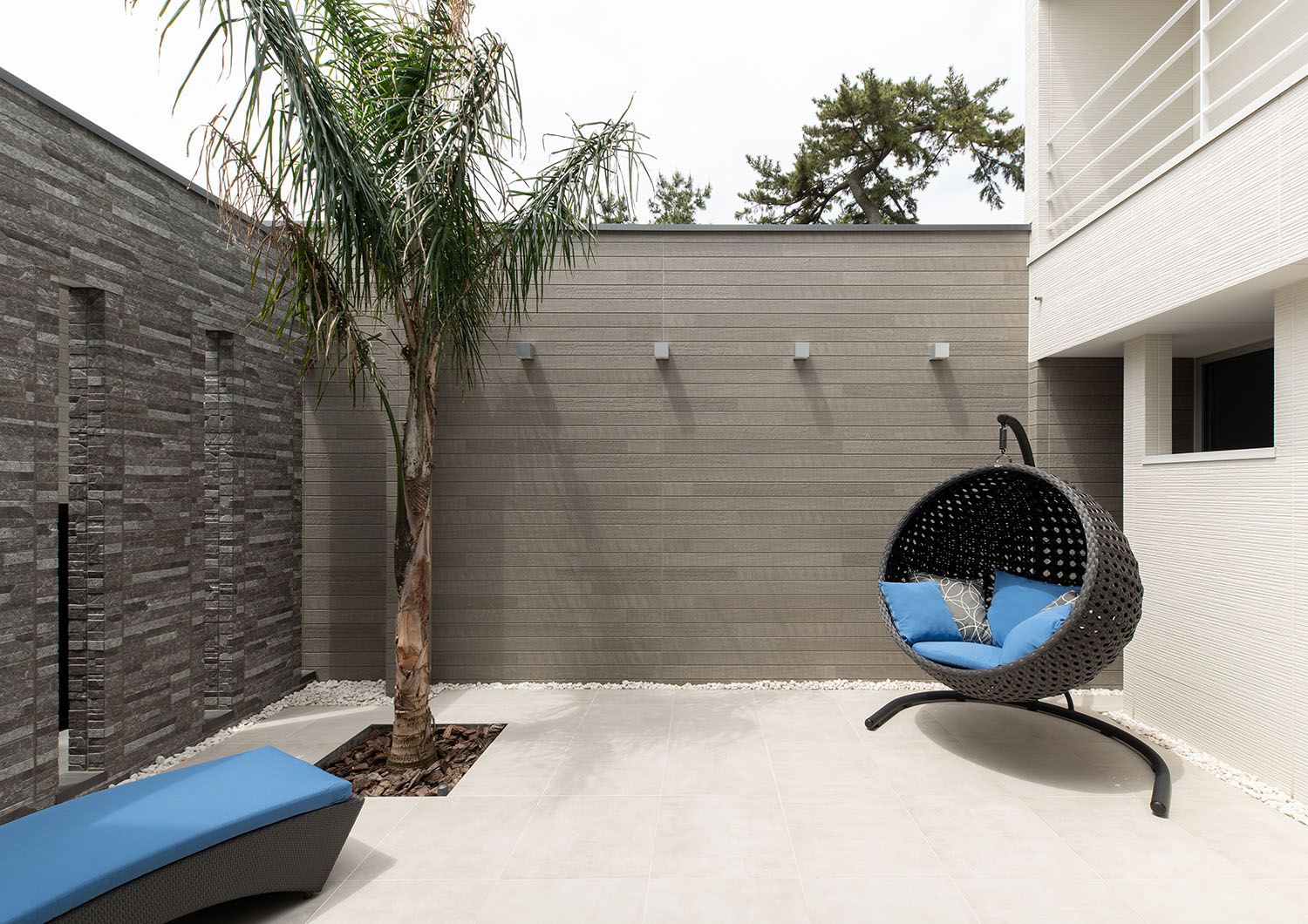 グレーの壁で囲まれておりヤシの木やハンモックチェアがある中庭・デザイン住宅 注文住宅・デザイン住宅建築実例_『CASE682  Casa de Resort』_中庭