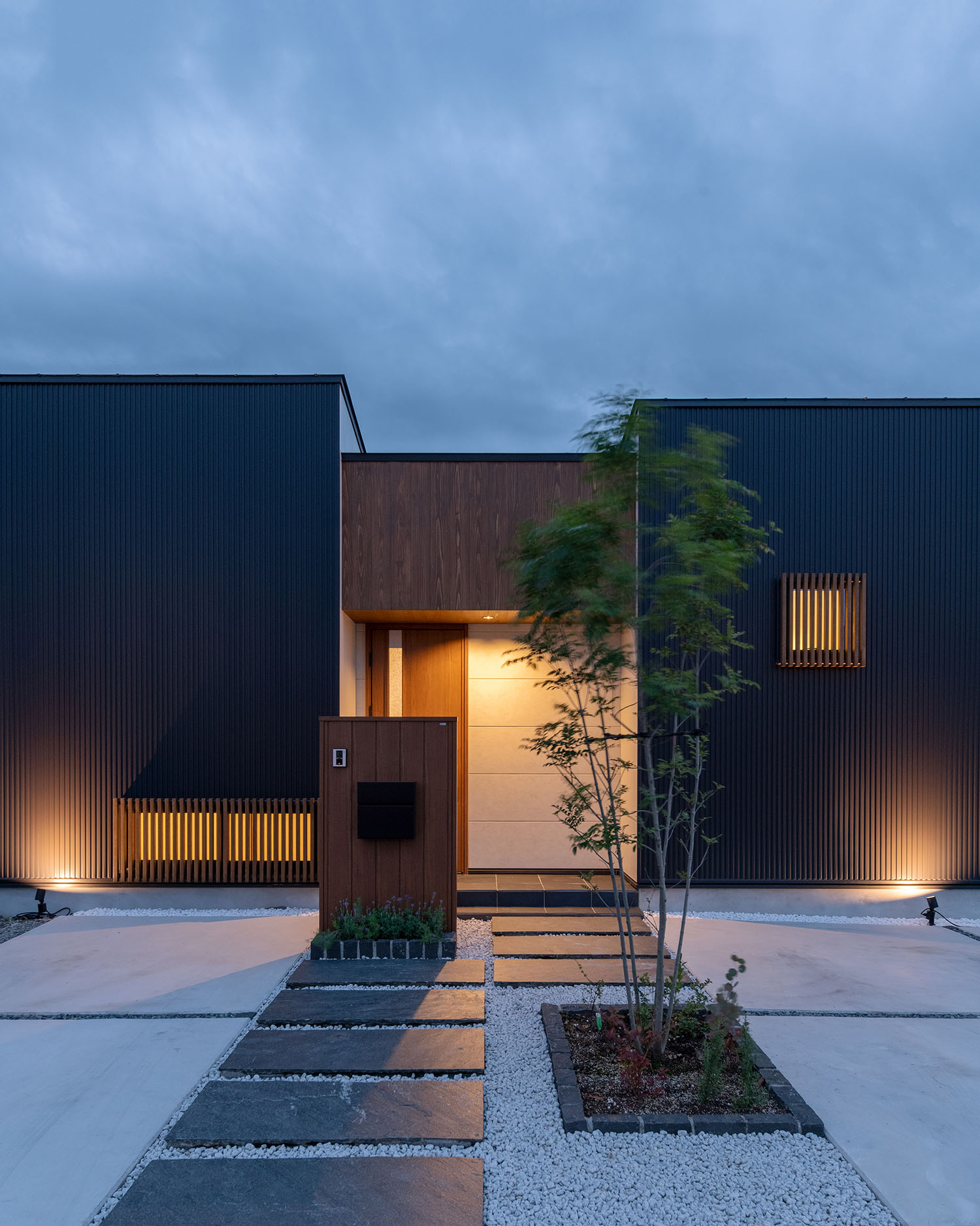 白い壁のエントランスが照明によって照らされる住宅・デザイン住宅 注文住宅・デザイン住宅建築実例_『CASE683  丘の上のハウス』_外観