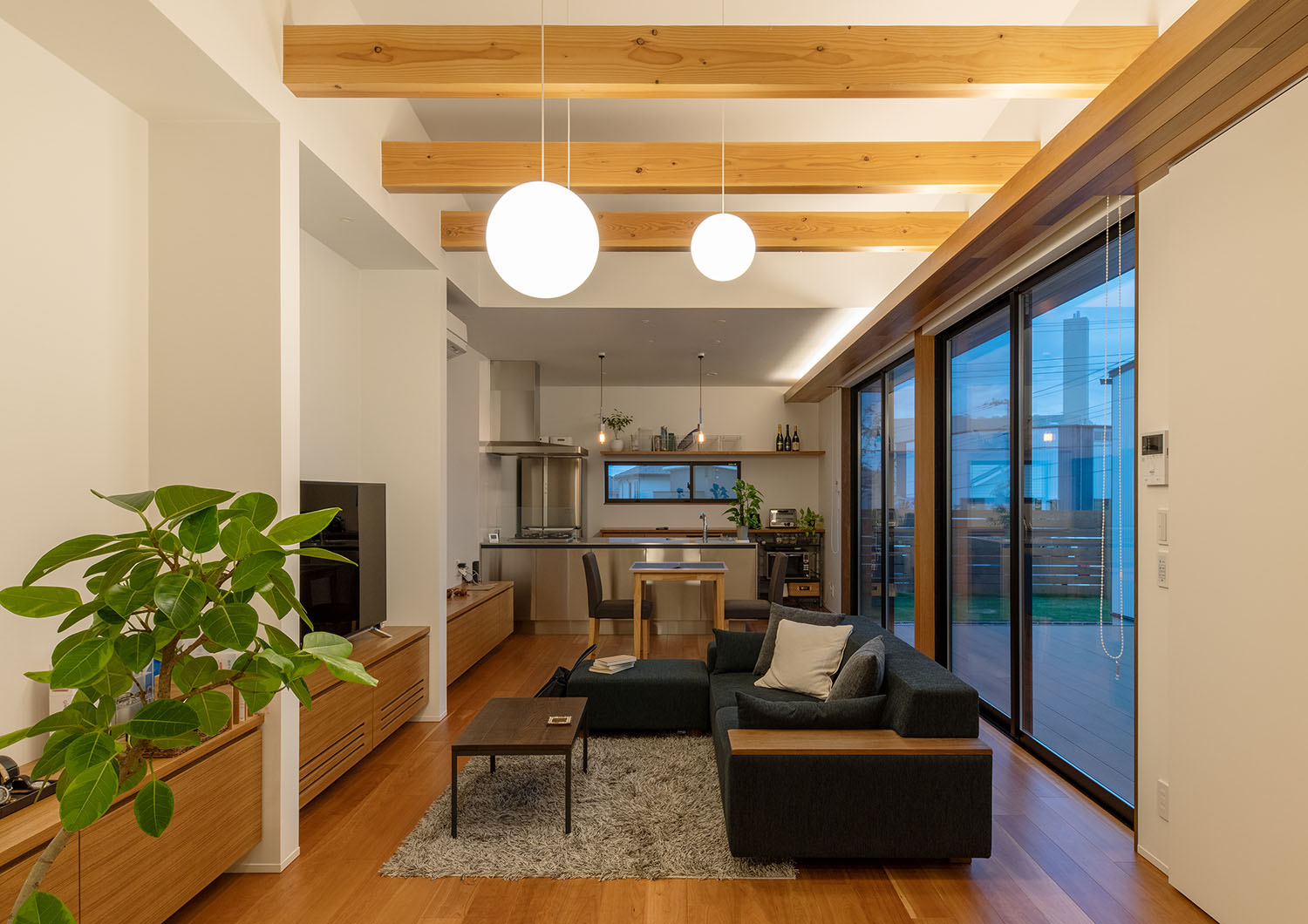 天井から吊り下げられたペンダントライトと、天井に仕込まれた間接照明に照らされるLDK・デザイン住宅 注文住宅・デザイン住宅建築実例_『CASE683  丘の上のハウス』_LDK