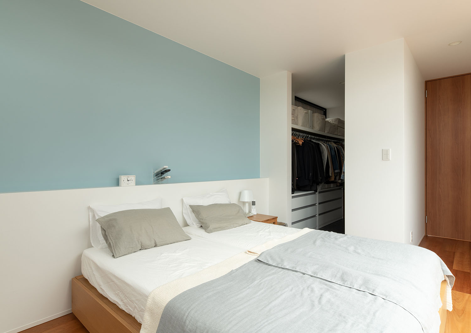 水色のアクセントクロスがあり、ウォークインクローゼットが繋がる寝室・デザイン住宅 注文住宅・デザイン住宅建築実例_『CASE683  丘の上のハウス』_寝室