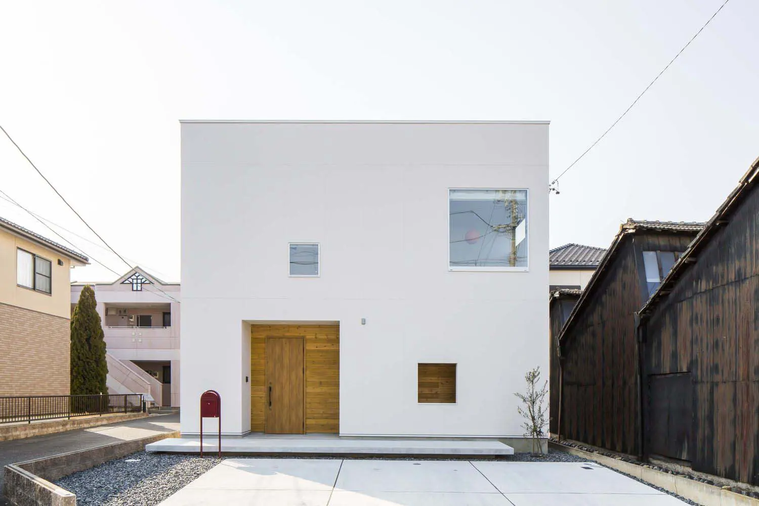 赤いポストがアクセントの四角い家