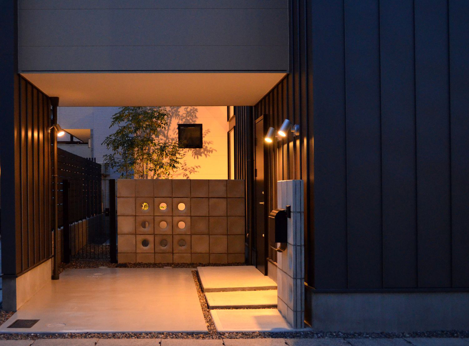 照明にライトアップされた植栽が目に入る玄関アプローチ・デザイン住宅