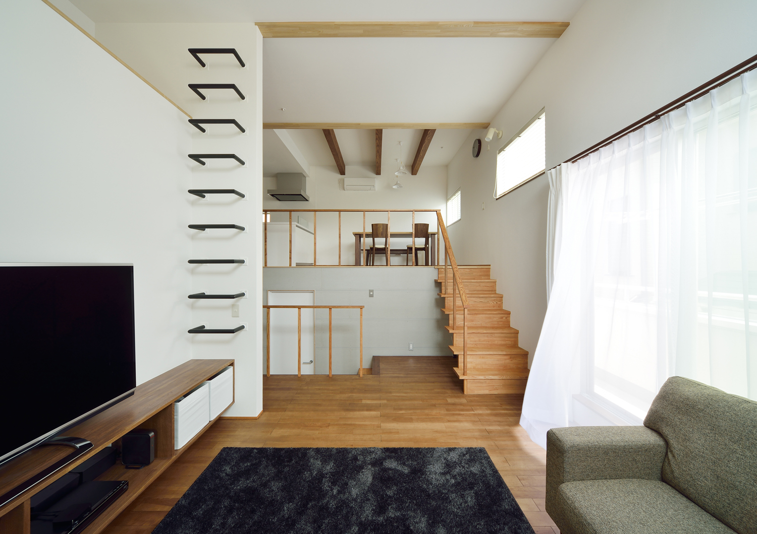 壁付けの階段からロフトに上がることが出来るスキップフロアで高天井のLDK・デザイン住宅