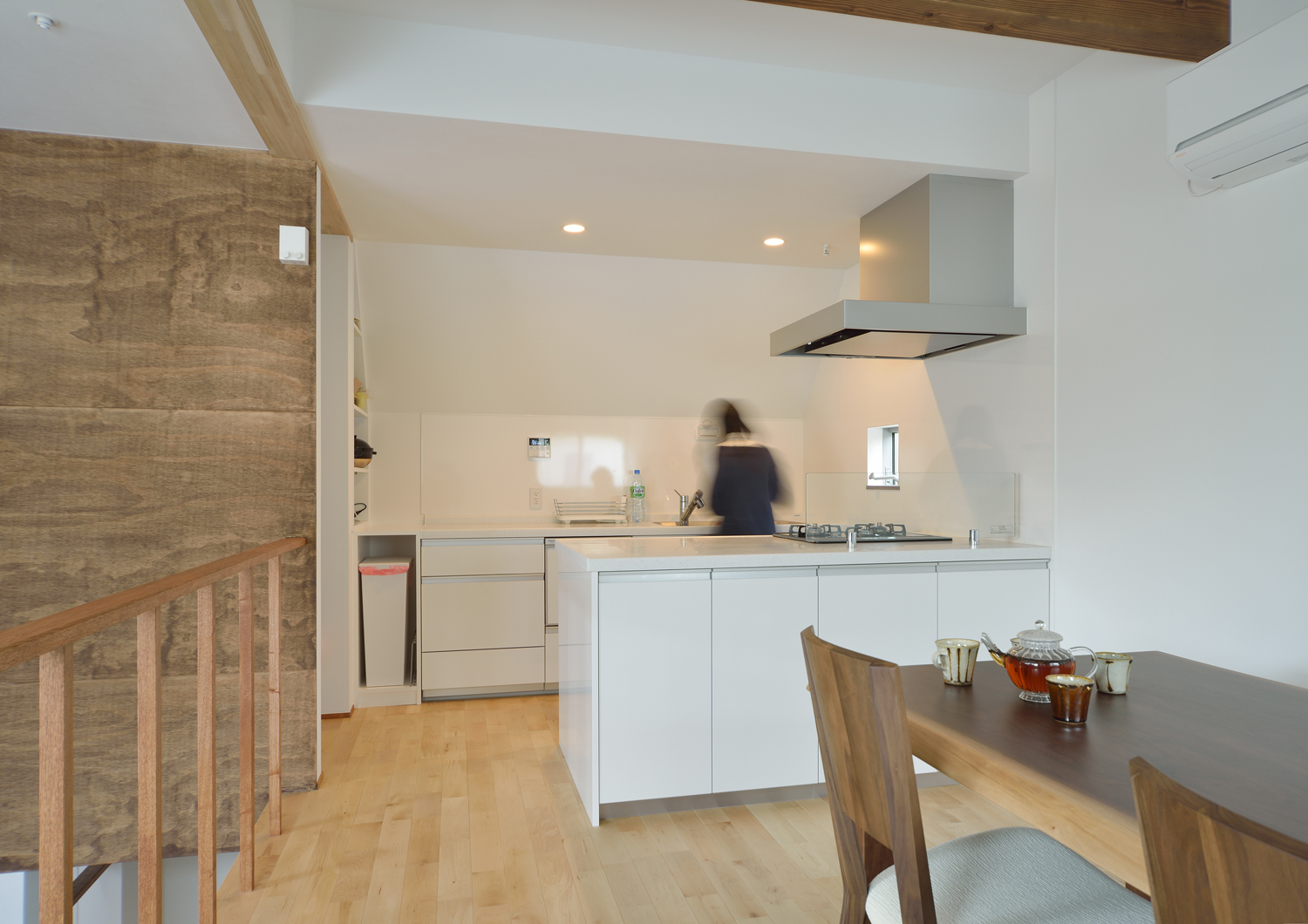 シンクとコンロが分かれた白いキッチンがあるシンプルで明るいLDK・デザイン住宅