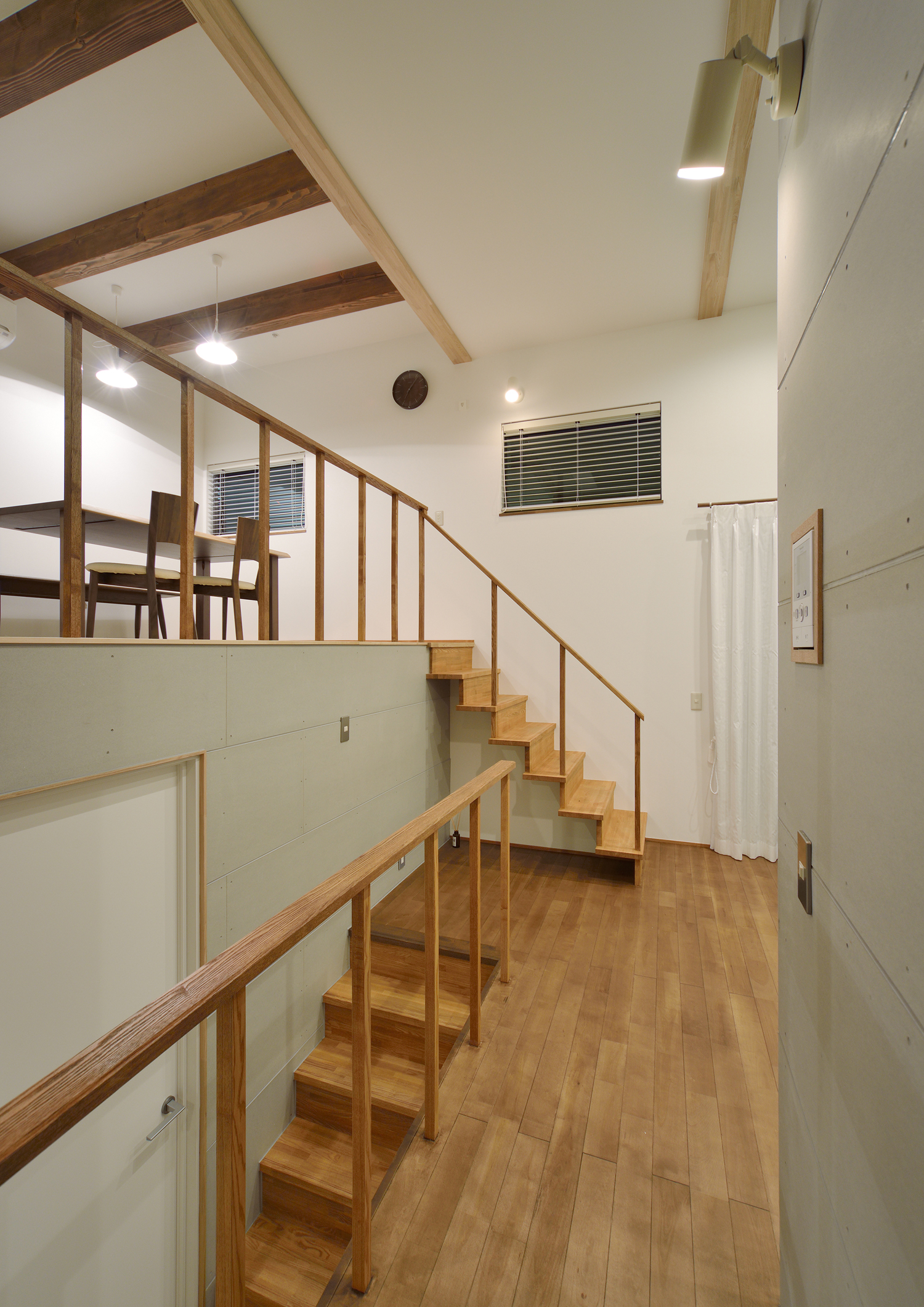 木の手すり付きの階段で繋がるスキップフロアのLDK・デザイン住宅