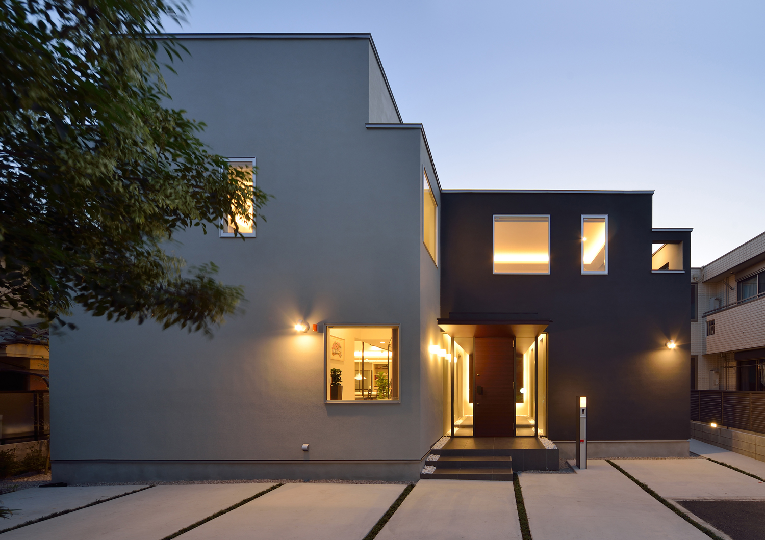 玄関扉の横のガラスから室内の様子が見える高級感のある外観の家・デザイン住宅