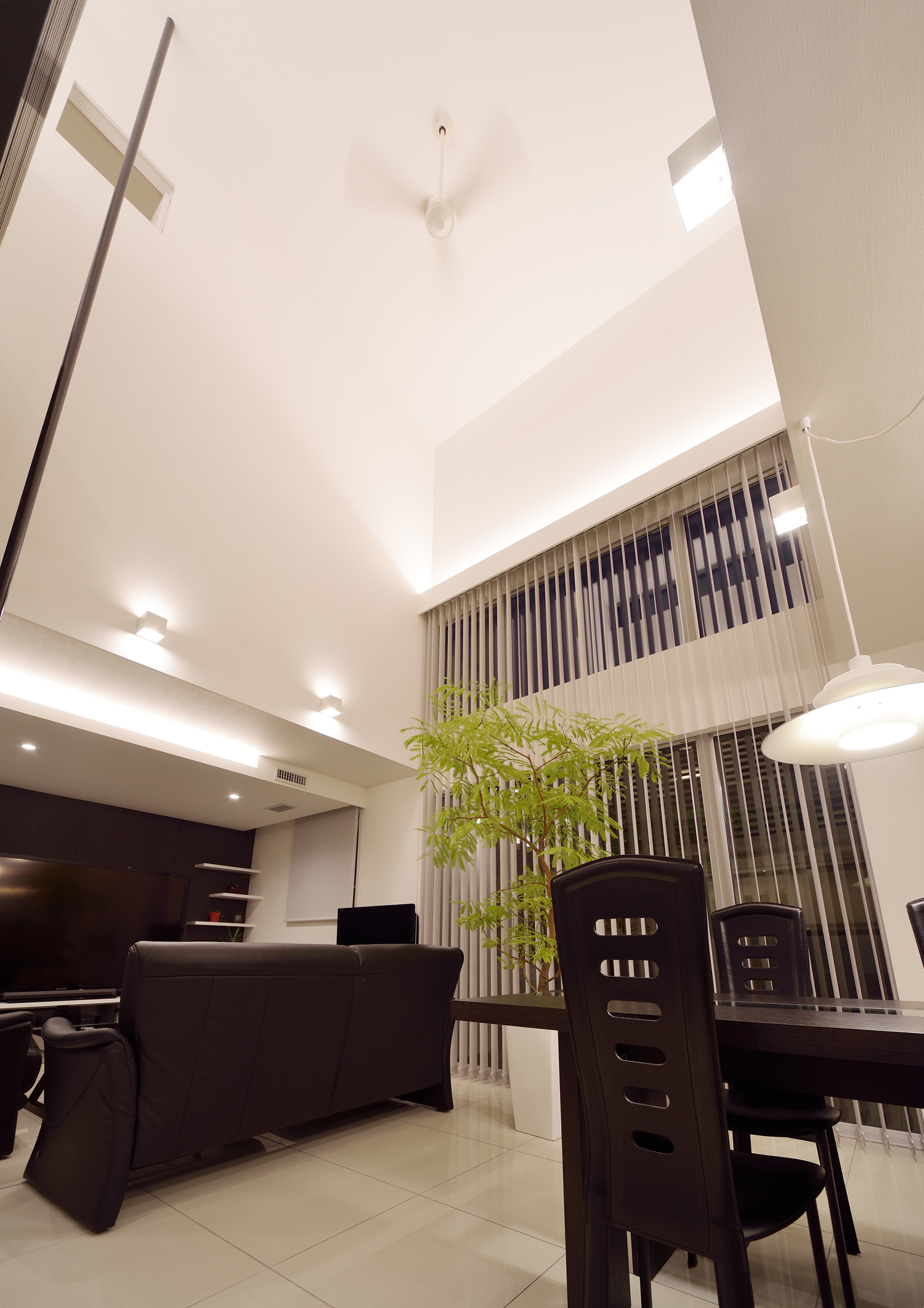 間接照明やペンダントライトを取り付けたモノトーンのおしゃれなLDK・デザイン住宅