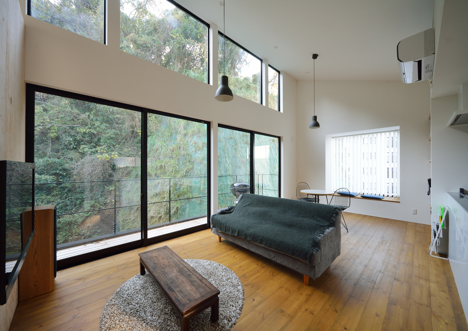 大きな窓から緑が見える吹き抜けのある開放的なLDK・デザイン住宅