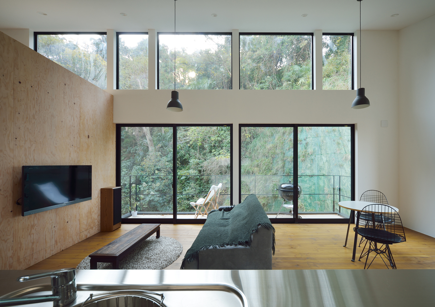 壁一面が窓になっている開放感のある吹き抜けのLDK・デザイン住宅